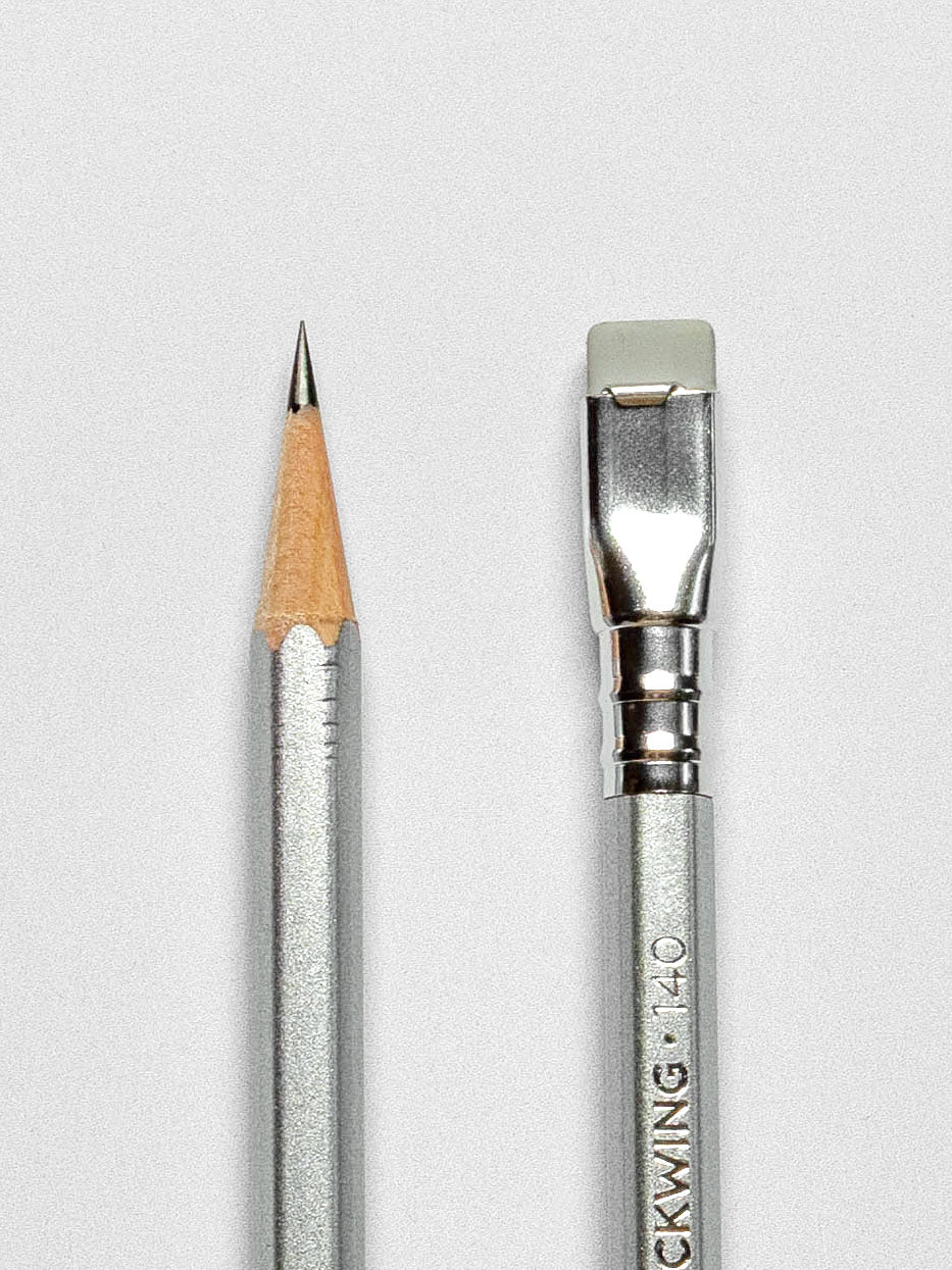 Close-up of the Blackwing 140 pencil, focusing on the sharpened graphite tip and the silver ferrule with a gray eraser.