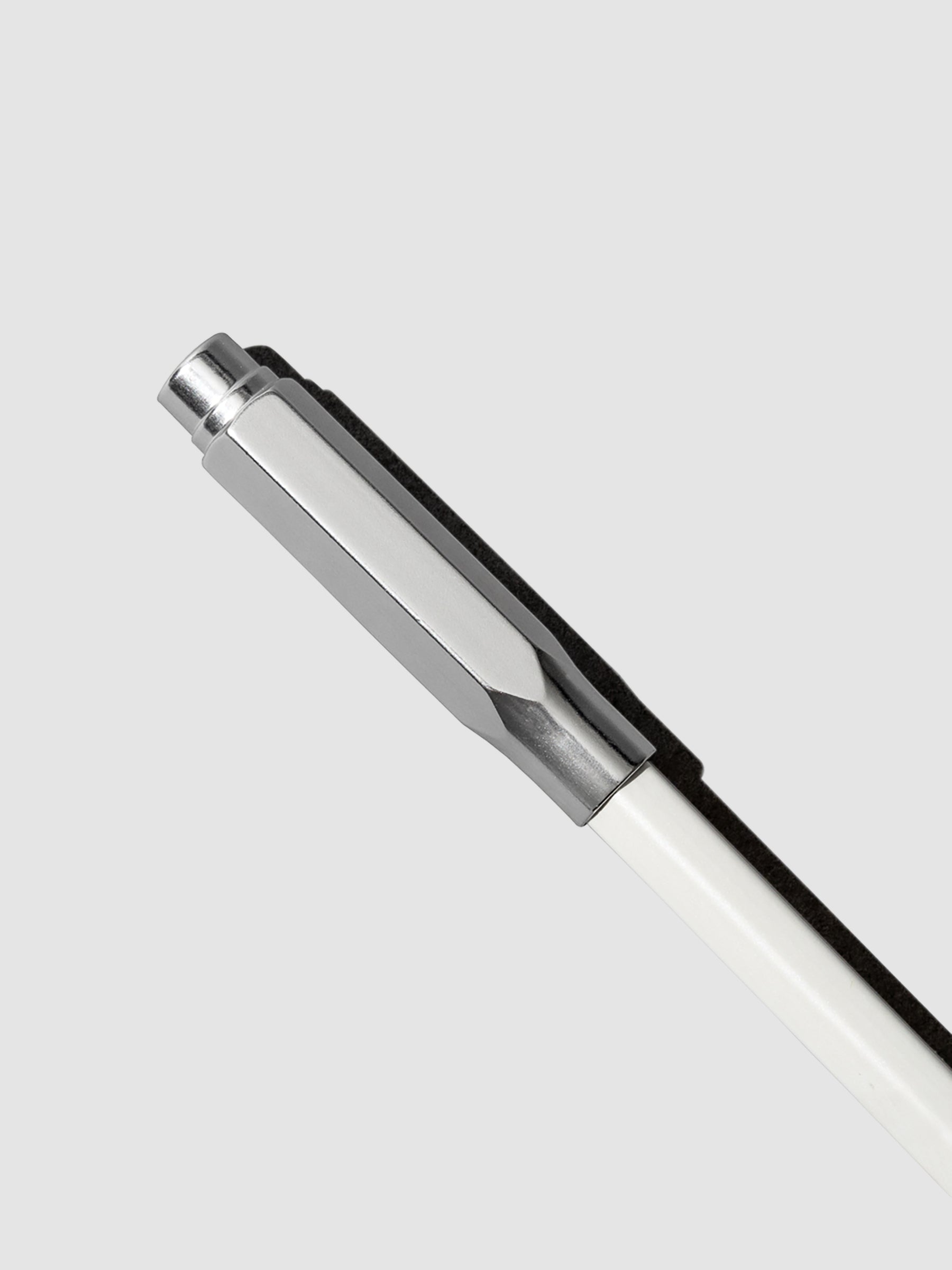The image shows the blackwing point guard in silver covering the sharpened tip of a white pencil.