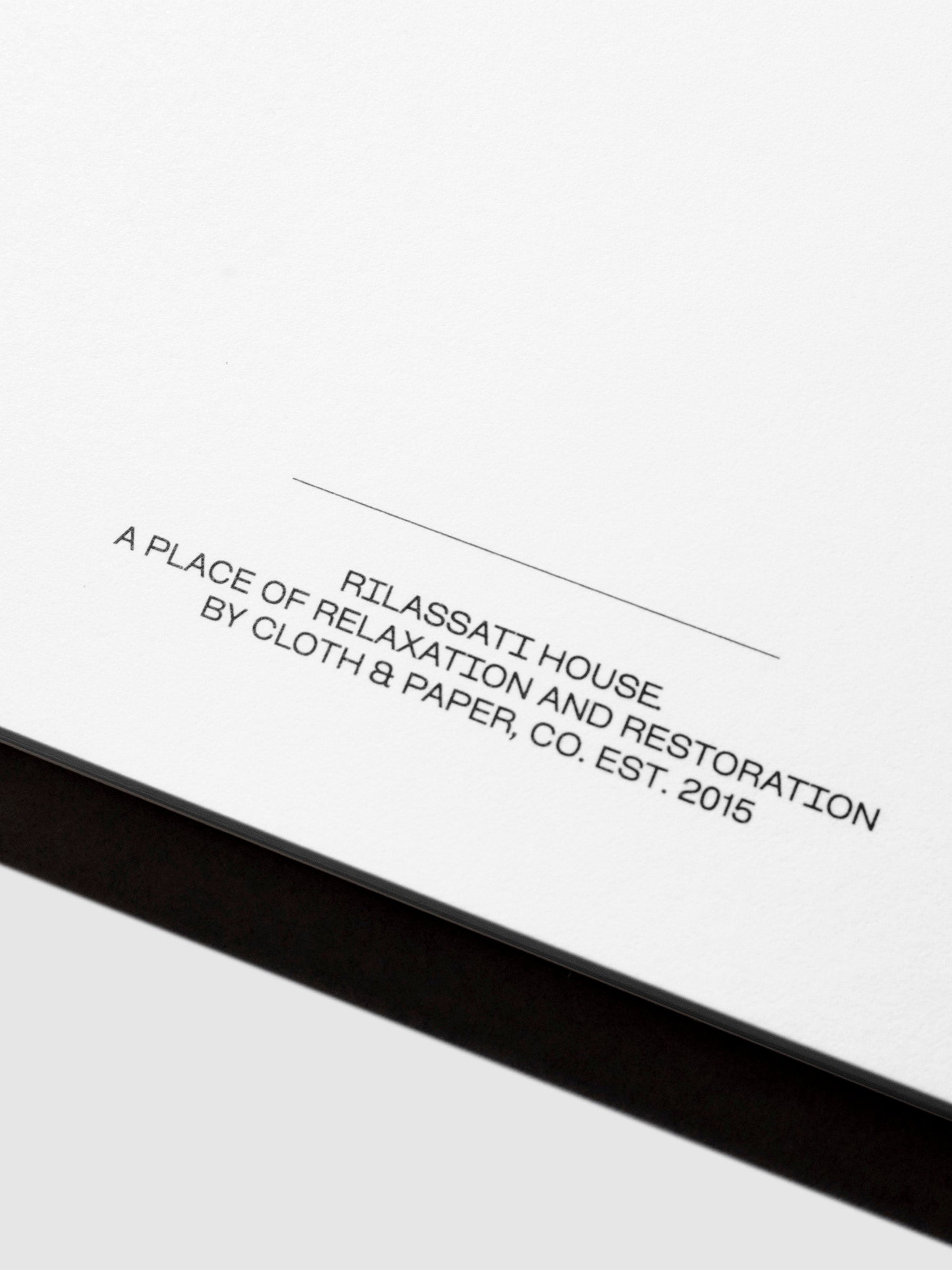 Closeup of notepad's footer text, which reads " RILASATTI HOUSE / A PLACE OF RELAXATION AND RESTORATION / BY CLOTH & PAPER, CO. EST. 2015"