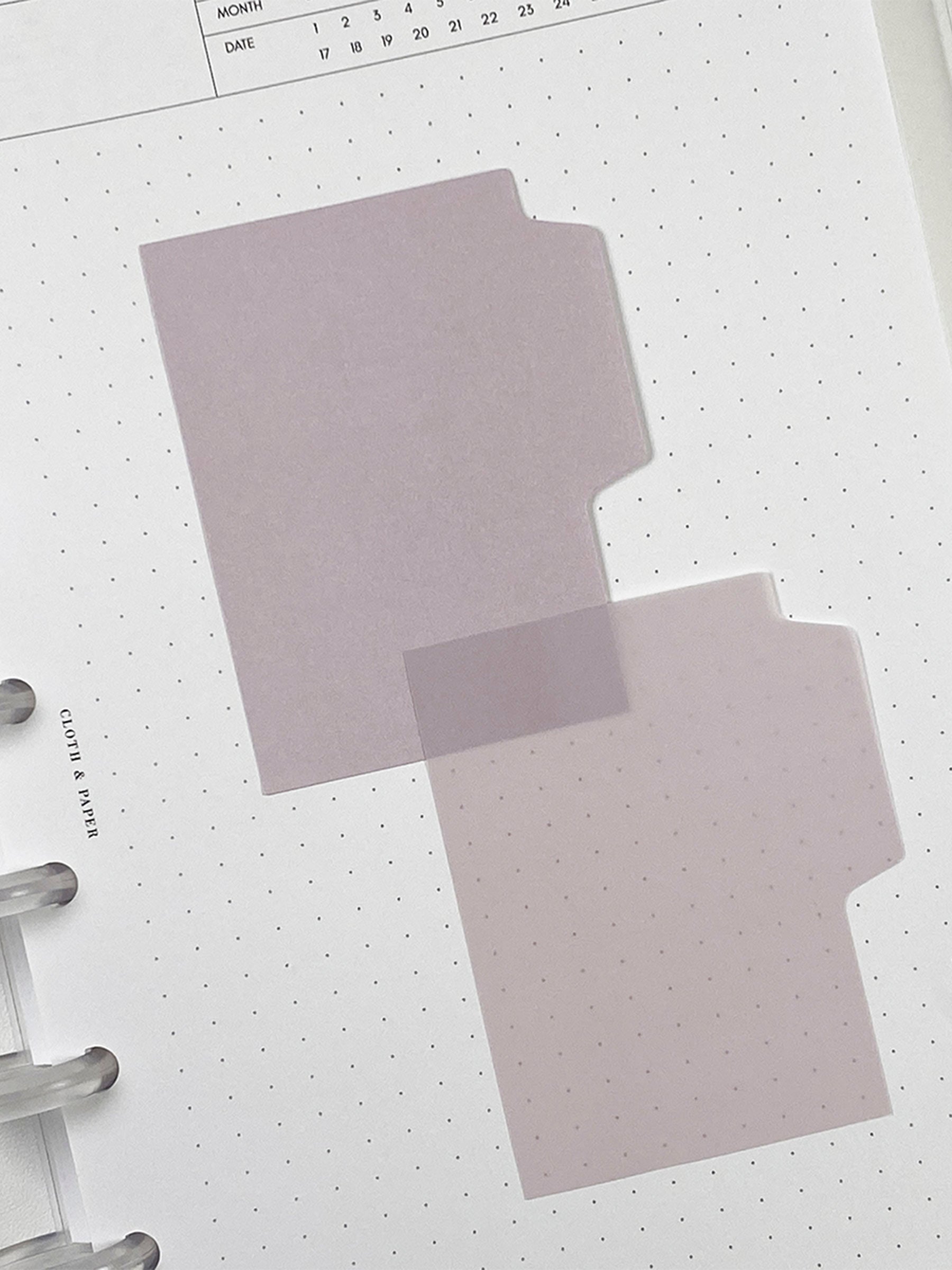 Blank Tab Sticky Note Set, Orchid, Cloth and Paper. One matte and one transparent sticky note from the set placed on a task insert. The transparent sticky note is layered over the bottom right corner of the matte sticky note.