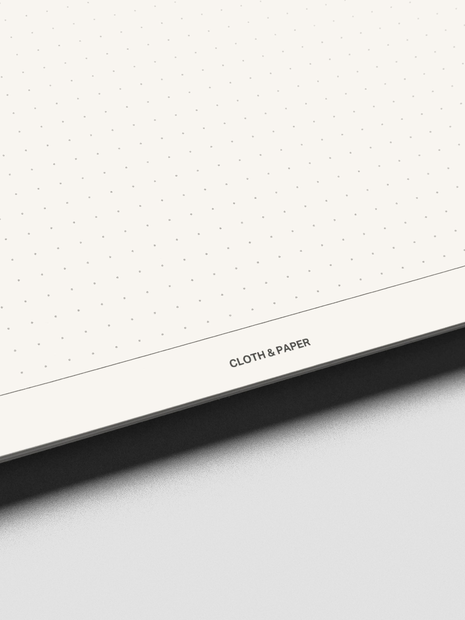 Close up view of the bottom of the Break Room notebook pages showing dot grid style and the Cloth & Paper logo.