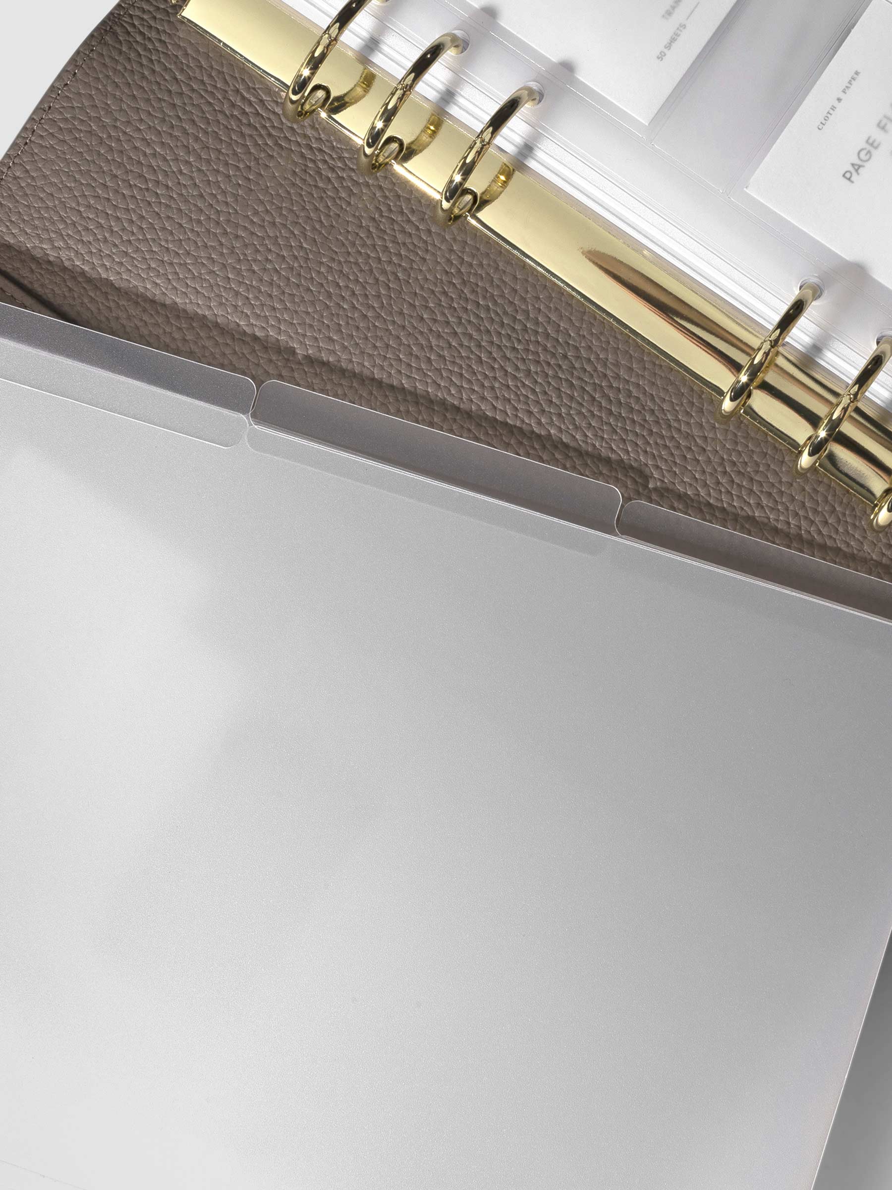 3 folders layered over each other placed on top of a fossil leather agenda.