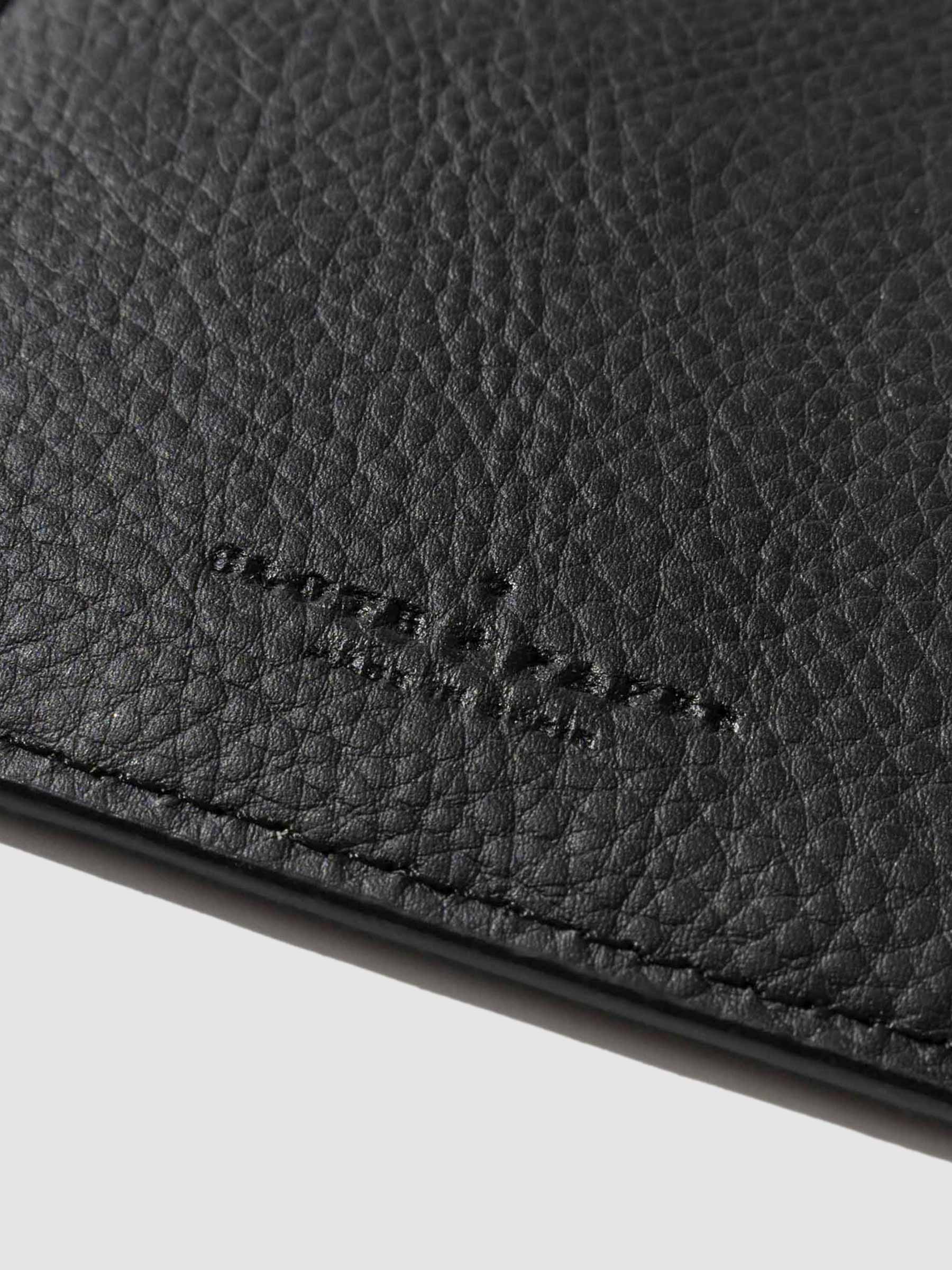 Closeup of mesa black folio's textured vegan leather and stamped Cloth and Paper logo.