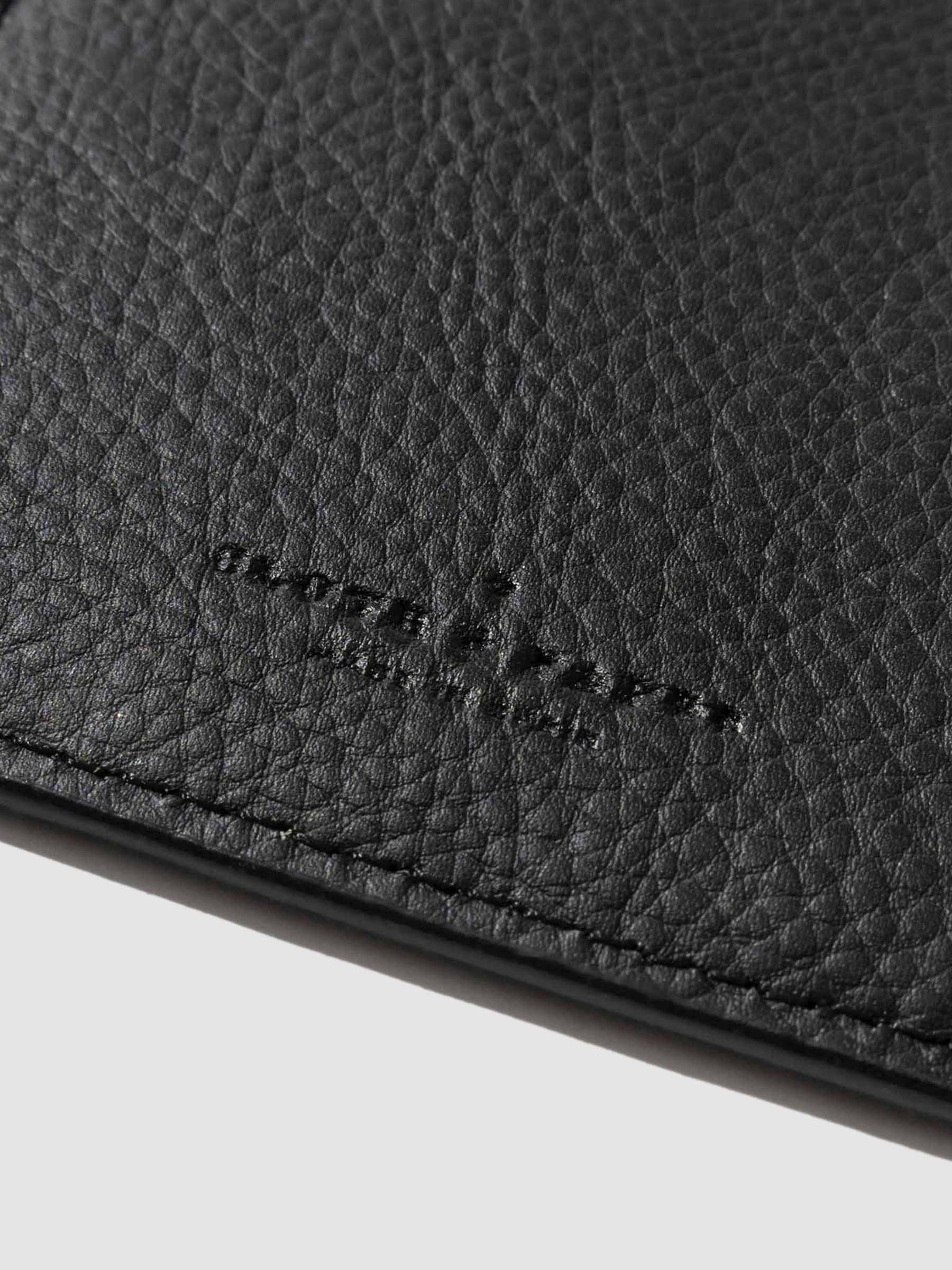 Closeup of mesa black folio's textured vegan leather and stamped Cloth and Paper logo.