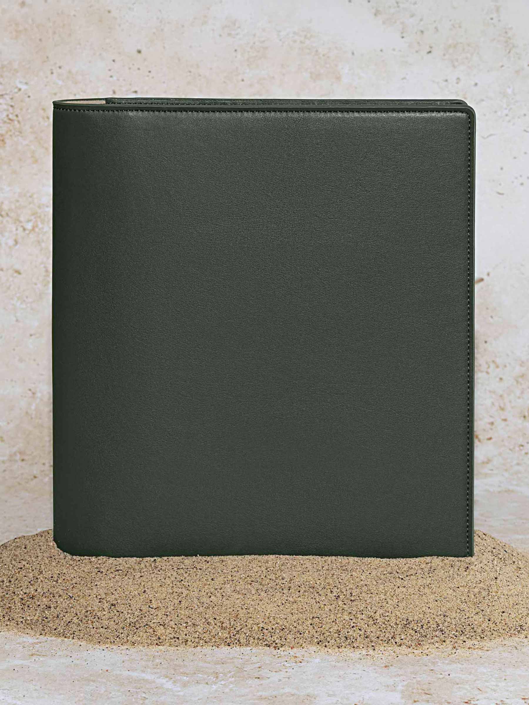 Folio displayed on a textured tan background, placed in a pile of sand. Color pictured is valley green. 