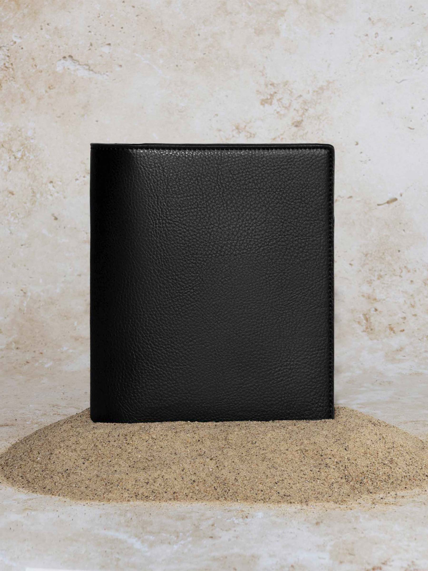 Cactus Vegan Leather Folio, HP Mini, Cloth and Paper. Folio displayed on a textured tan background, placed in a pile of sand. Color pictured is mesa black.