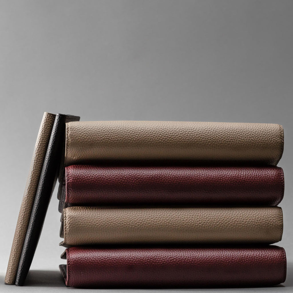 am image with leather planners in black, fossil, and wine stacked 