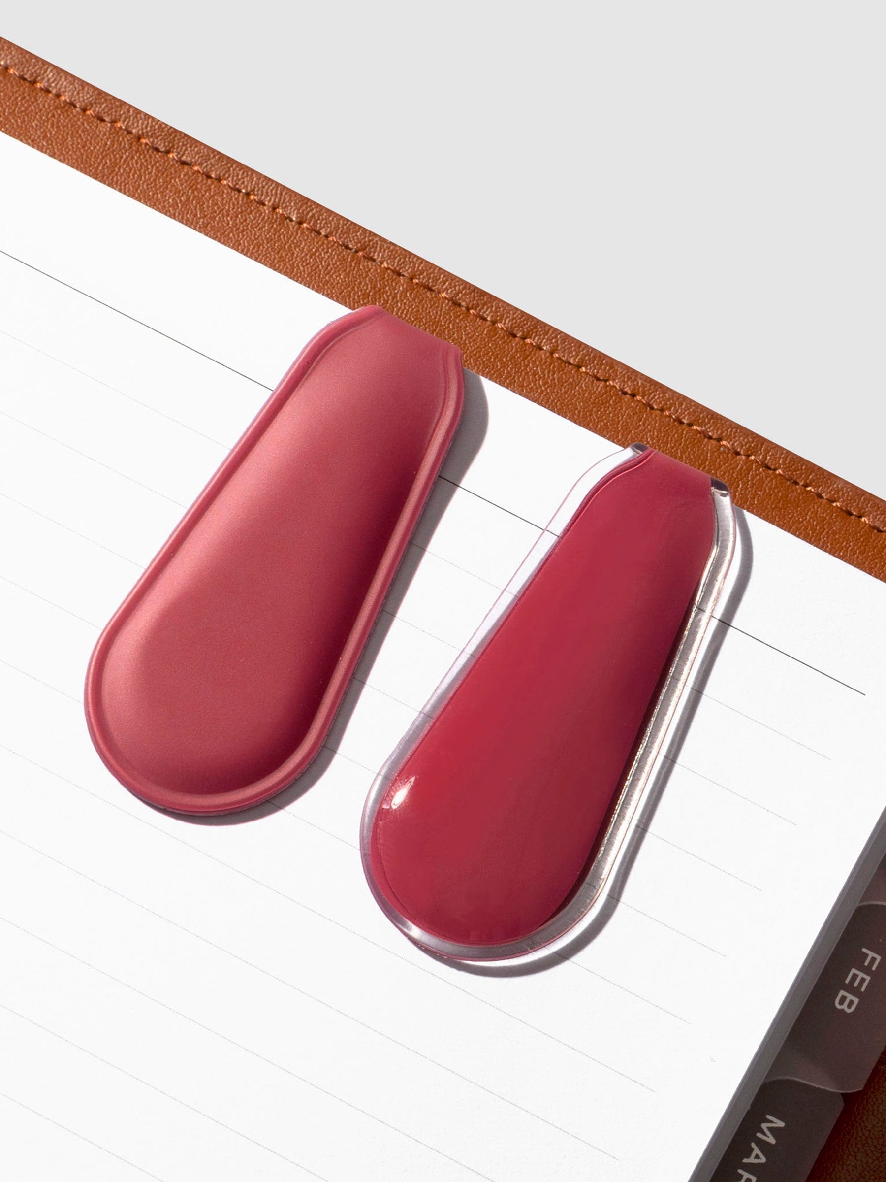 Set of clips displayed inside a light brown leather agenda.