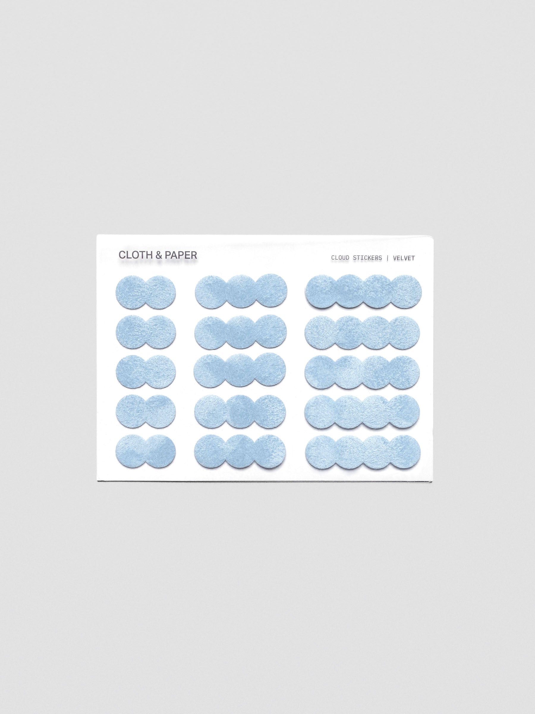 A sticker sheet of cloud-shaped, blue, velvet stickers shown in three sizes for a total of 15 stickers.