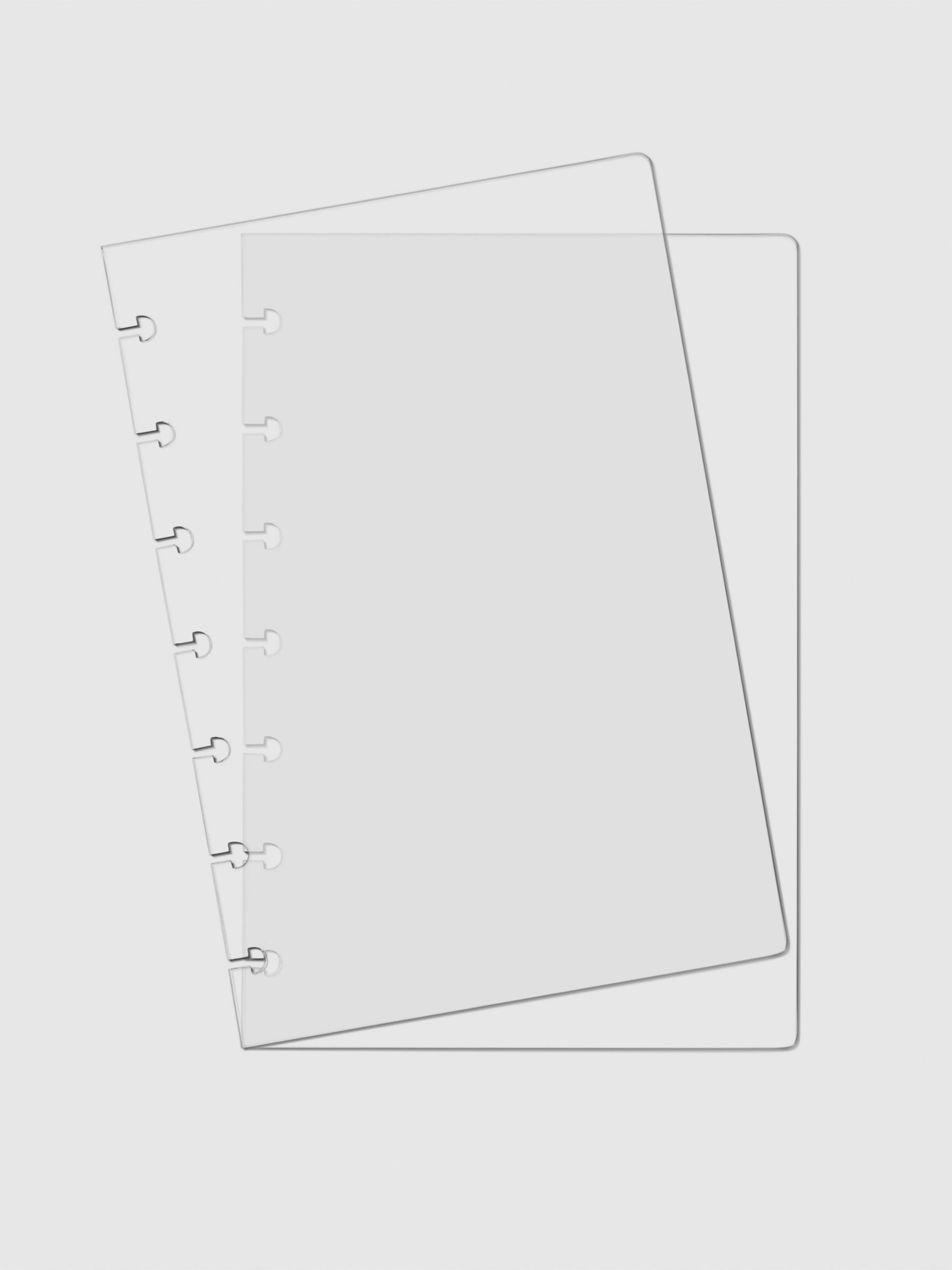 Two Crystal Clear Discbound Notebook Covers laid on top of one another with the top cover tilted slightly to the left.