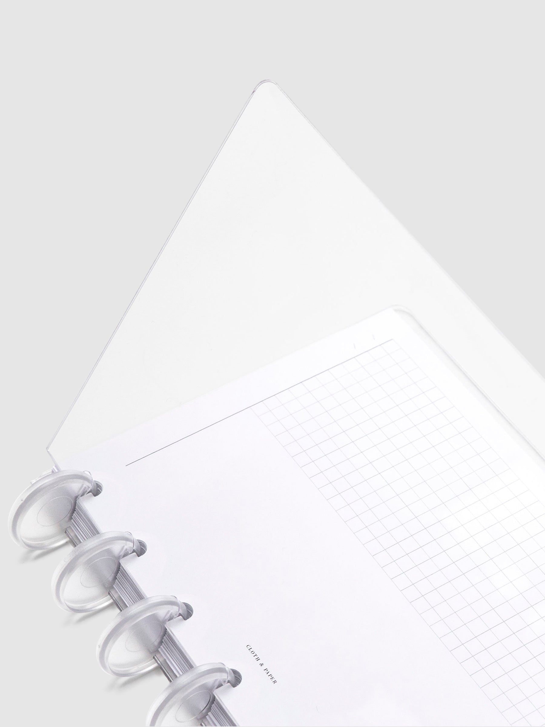 Crystal Clear Discbound Notebook Cover, HP Mini, Cloth and Paper. Close up image of notebook covers in use with clear rings and an insert. The front cover is opened halfway.