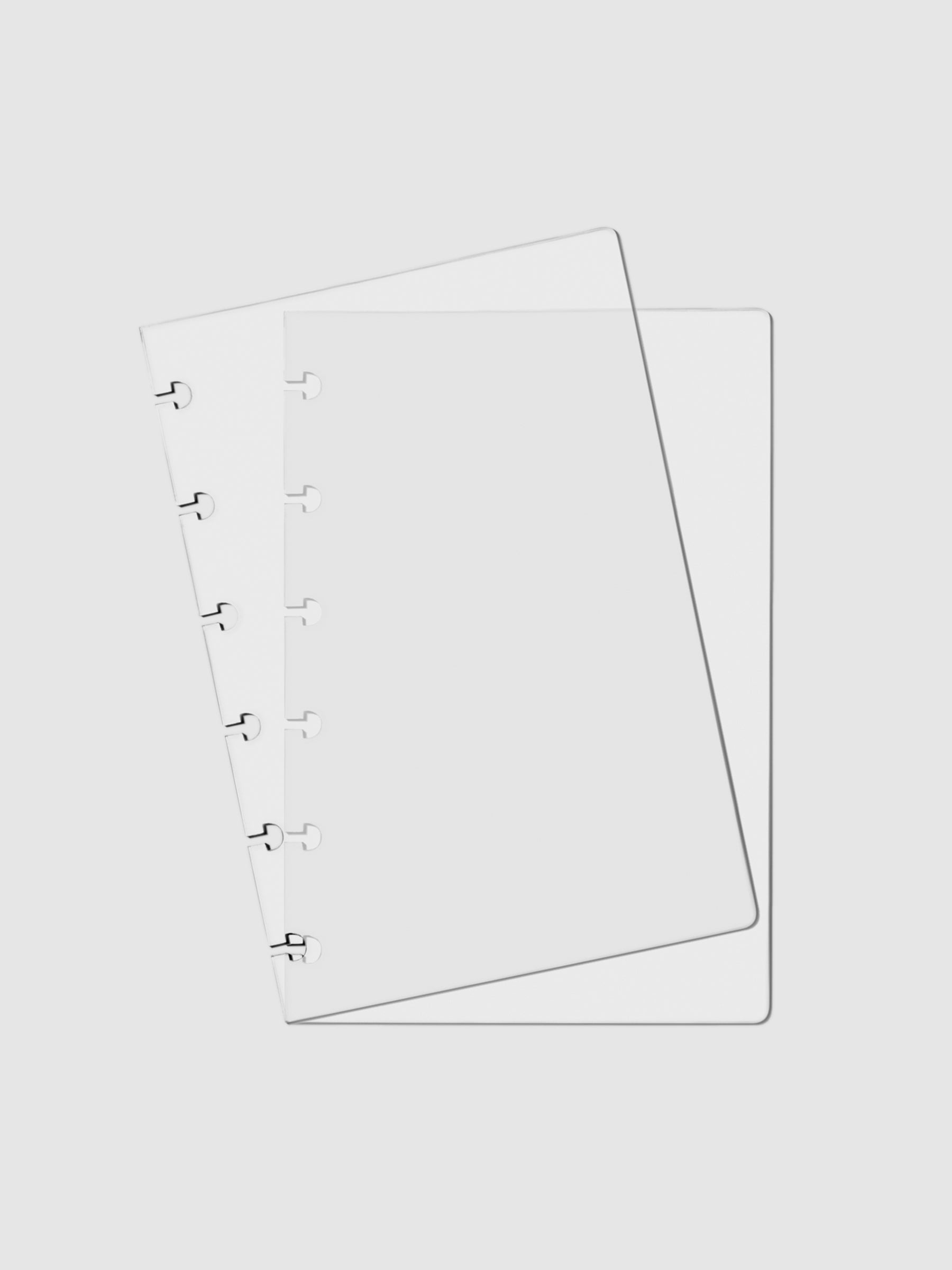 Crystal Clear Discbound Notebook Cover, CP Petite, Cloth and Paper. Two transparent notebook covers laid on top of one another with the top cover tilted slightly to the left.