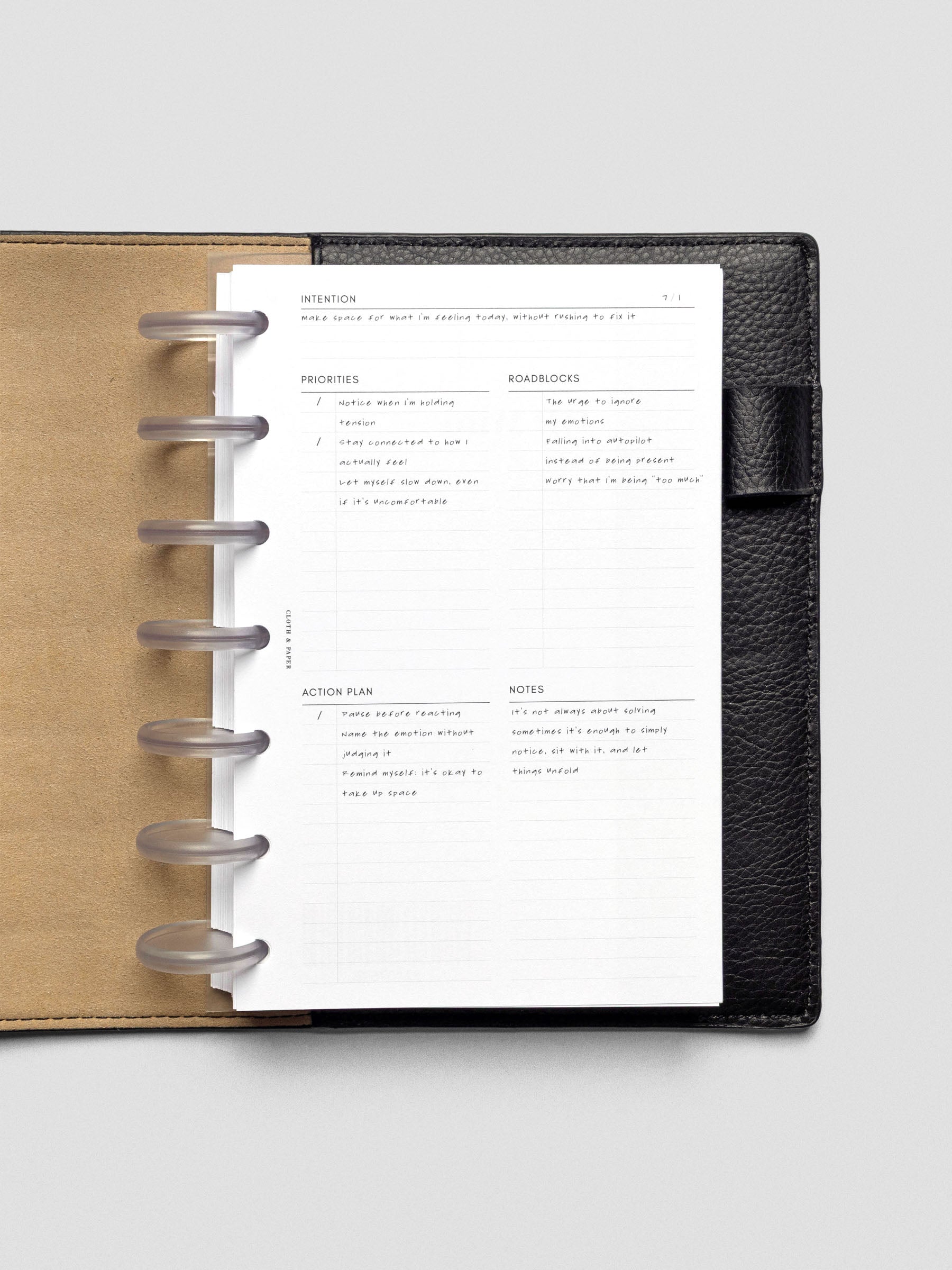 Daily Intention Planner Inserts show filled out in Half Letter size disc bound in a leather cover.