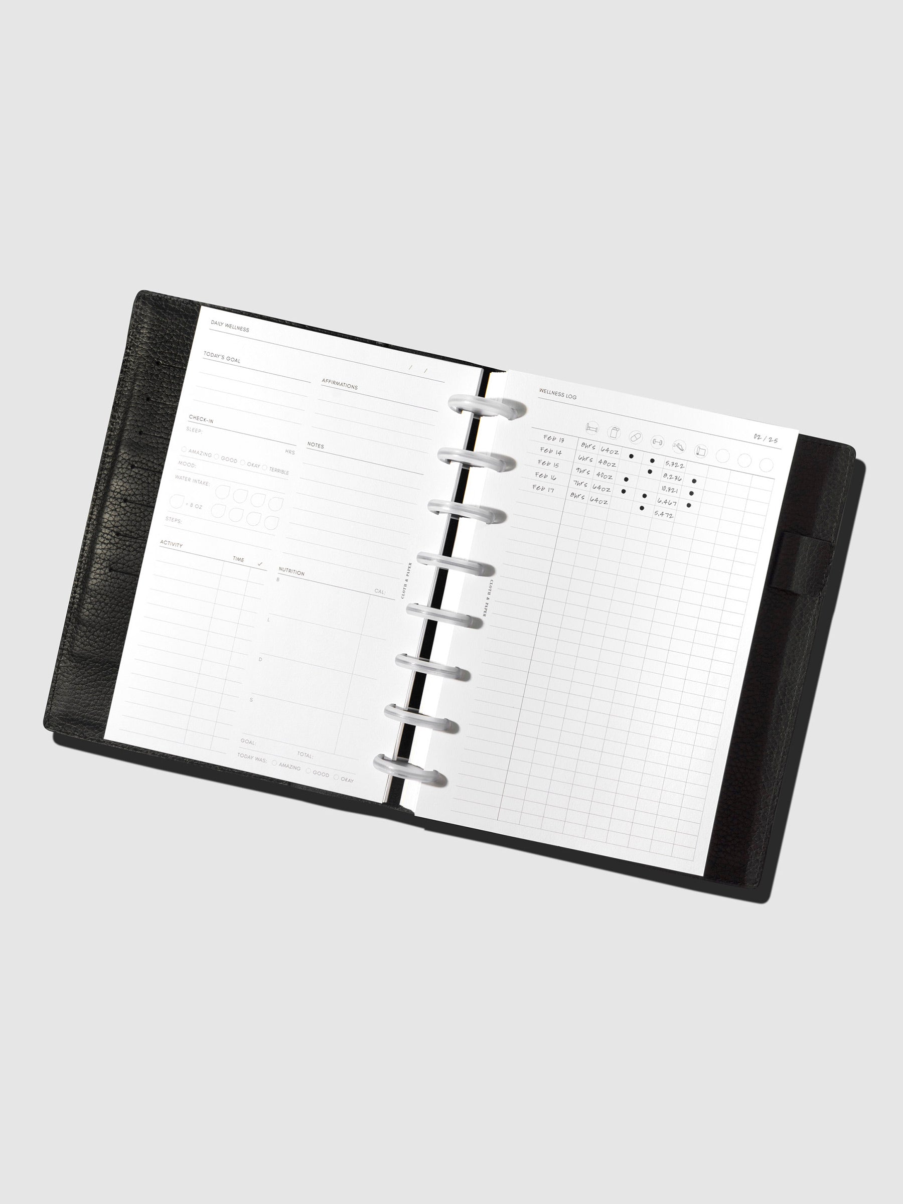 Daily wellness page inside a black leather planner.