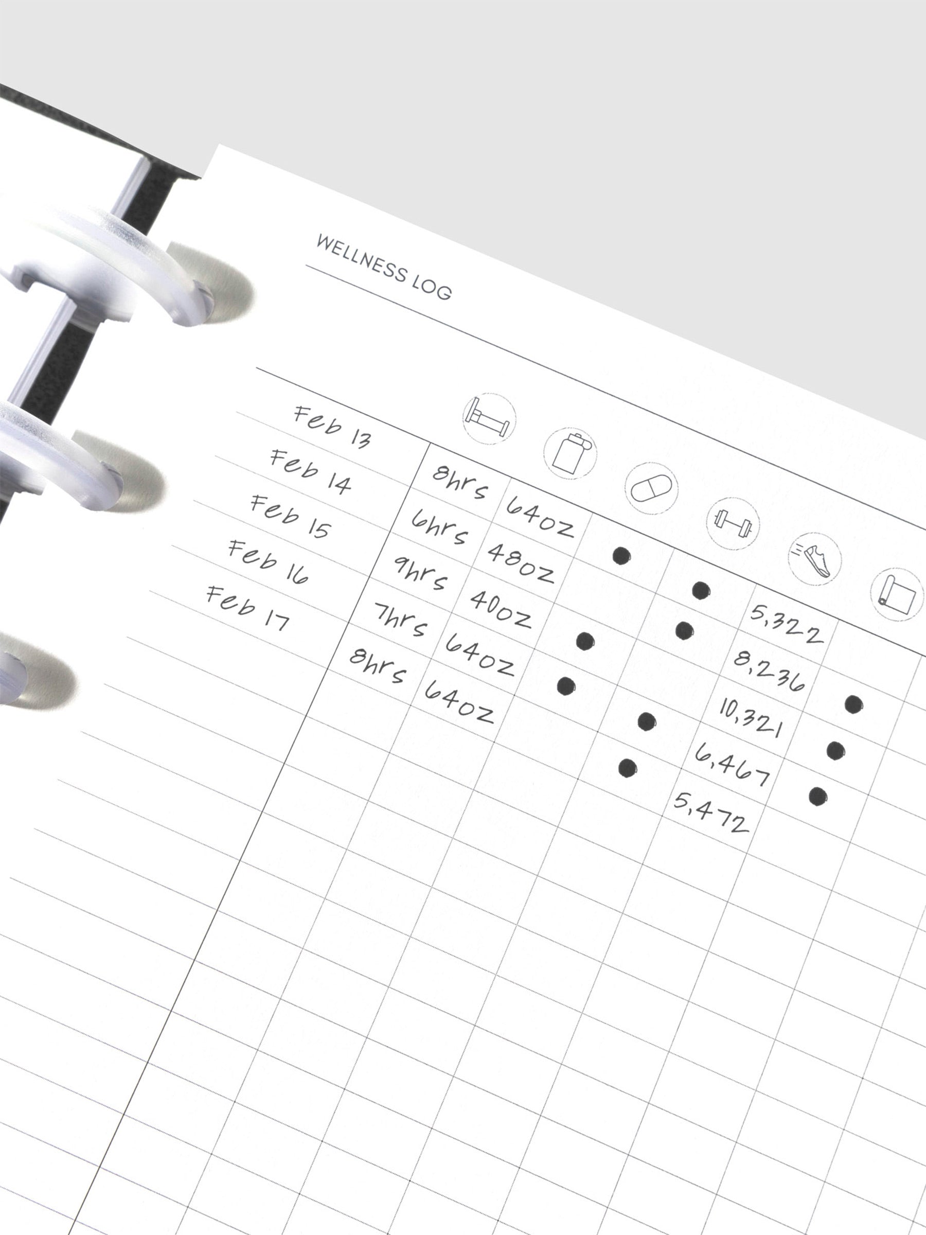 Closeup of daily wellness page inside a black leather planner.