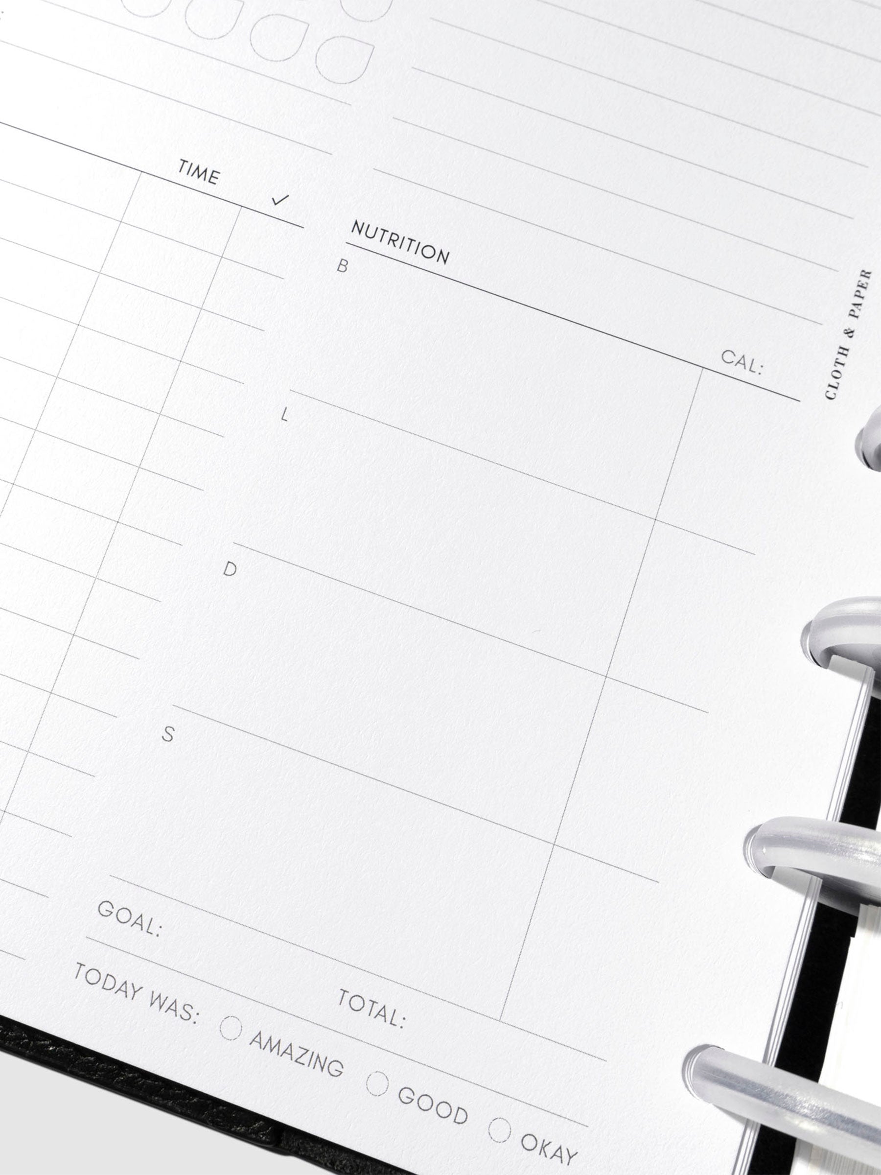 Closeup of daily wellness page inside a black leather planner.