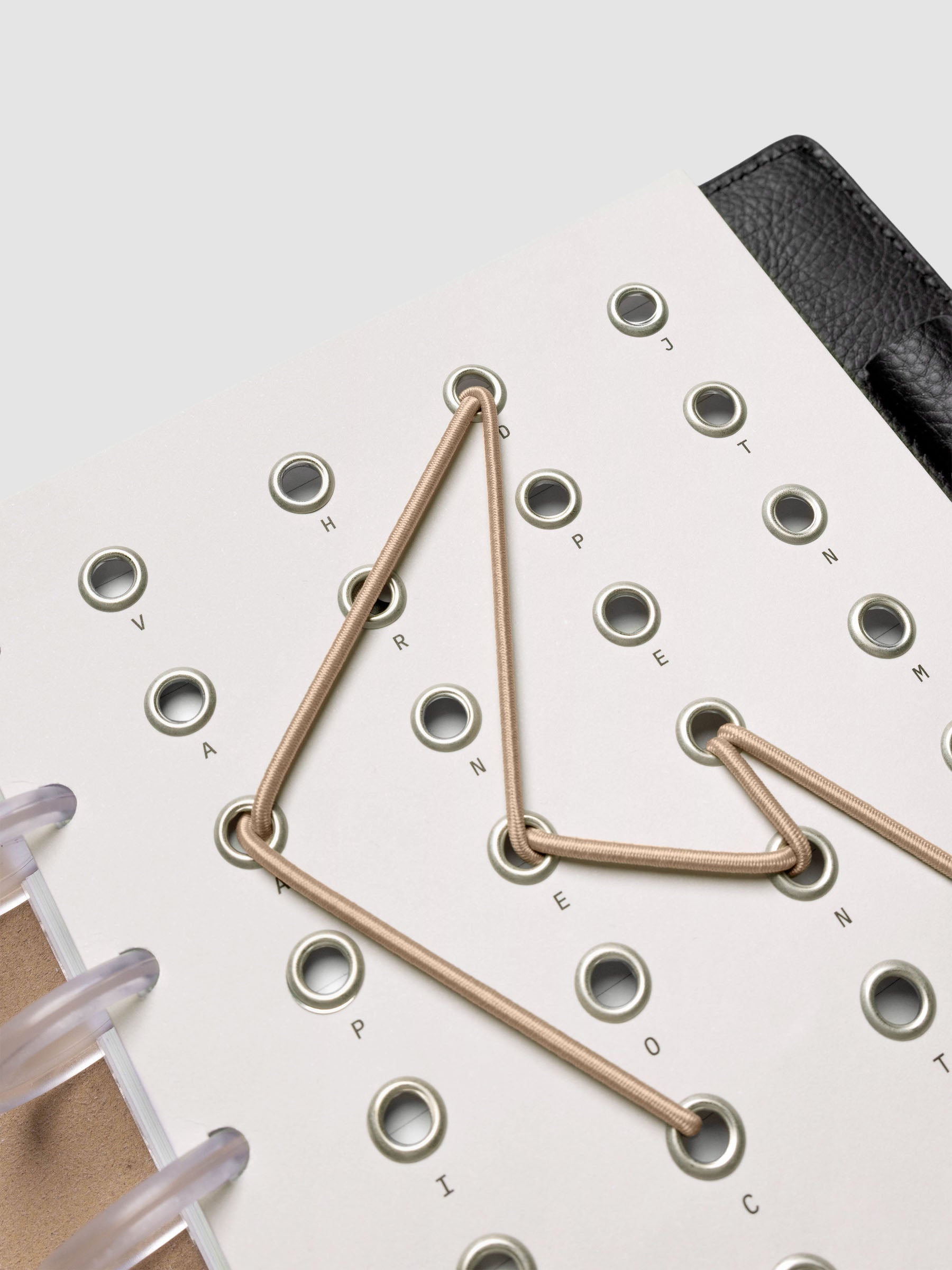 Cadence Dashboard with grommets and string on beige cardstock shown close up in a discbound planner.