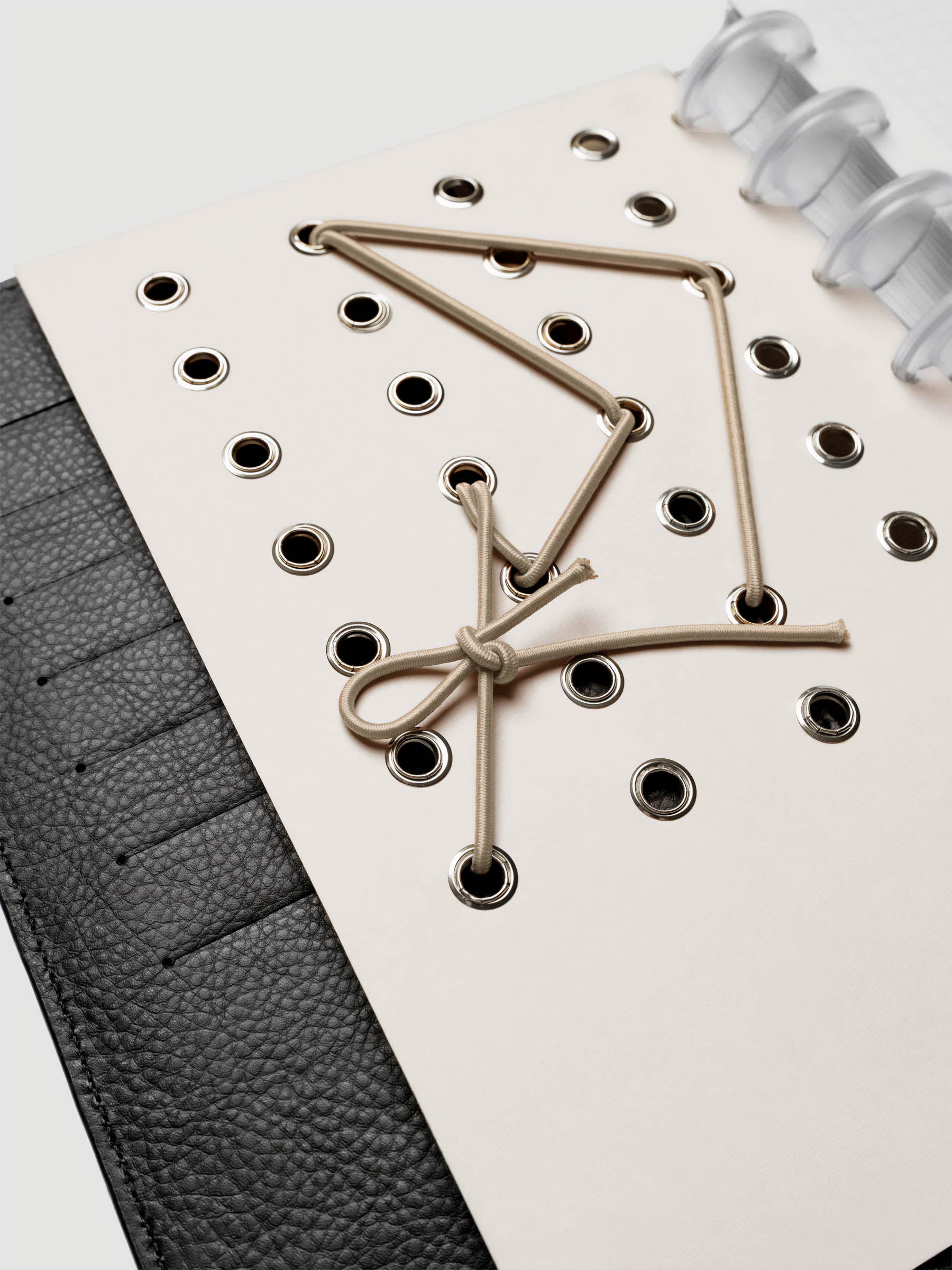 Cadence Dashboard with grommets and string on beige cardstock shown close up in a discbound planner.