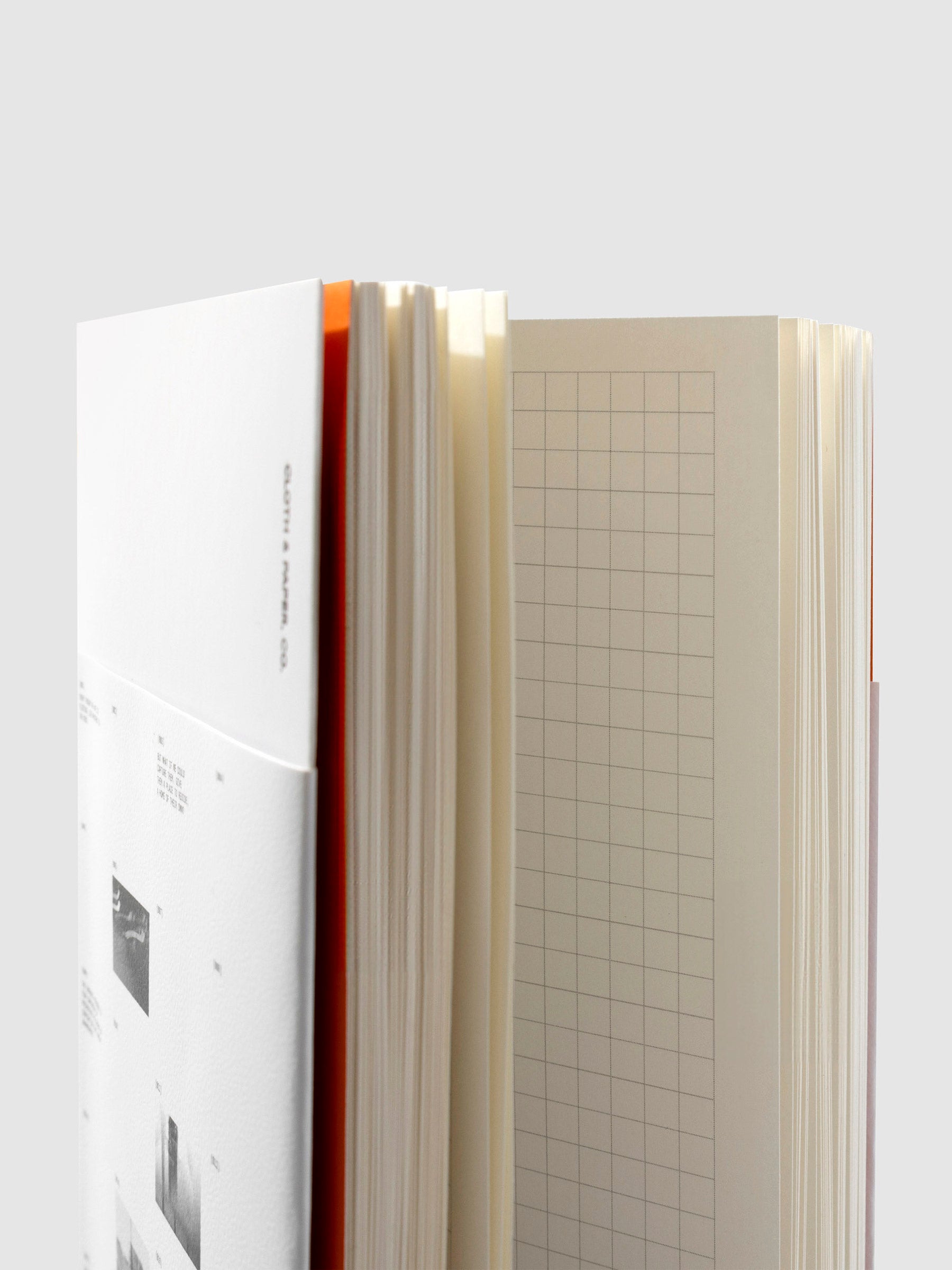 Notebook displayed on a neutral background. The photo is shot close up, revealing orange cover accents and a graph page layout.