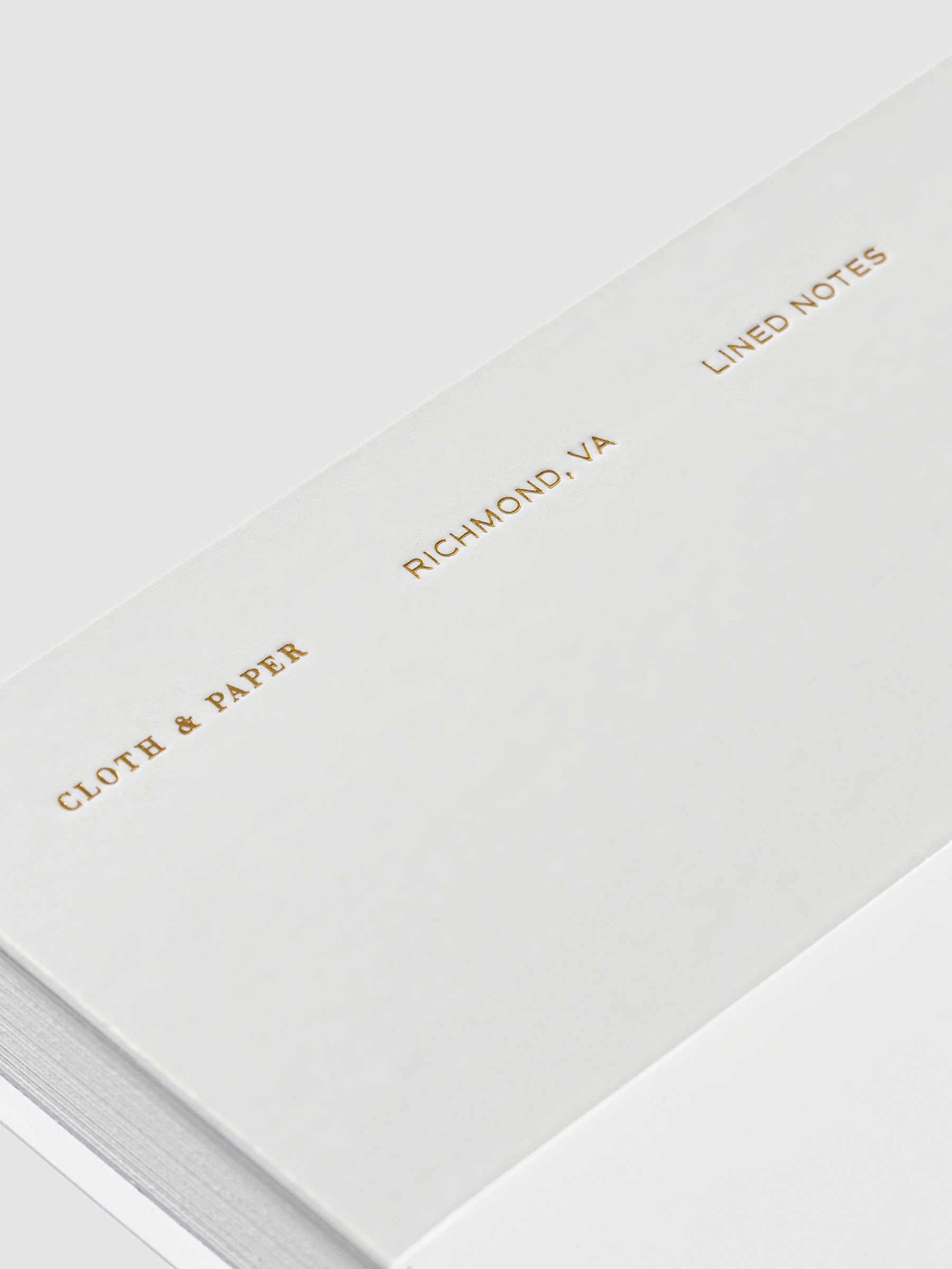 Closeup of text on Ash notebook that reads from bottom to top - "Cloth & Paper / Richmond, VA / Lined Notes"