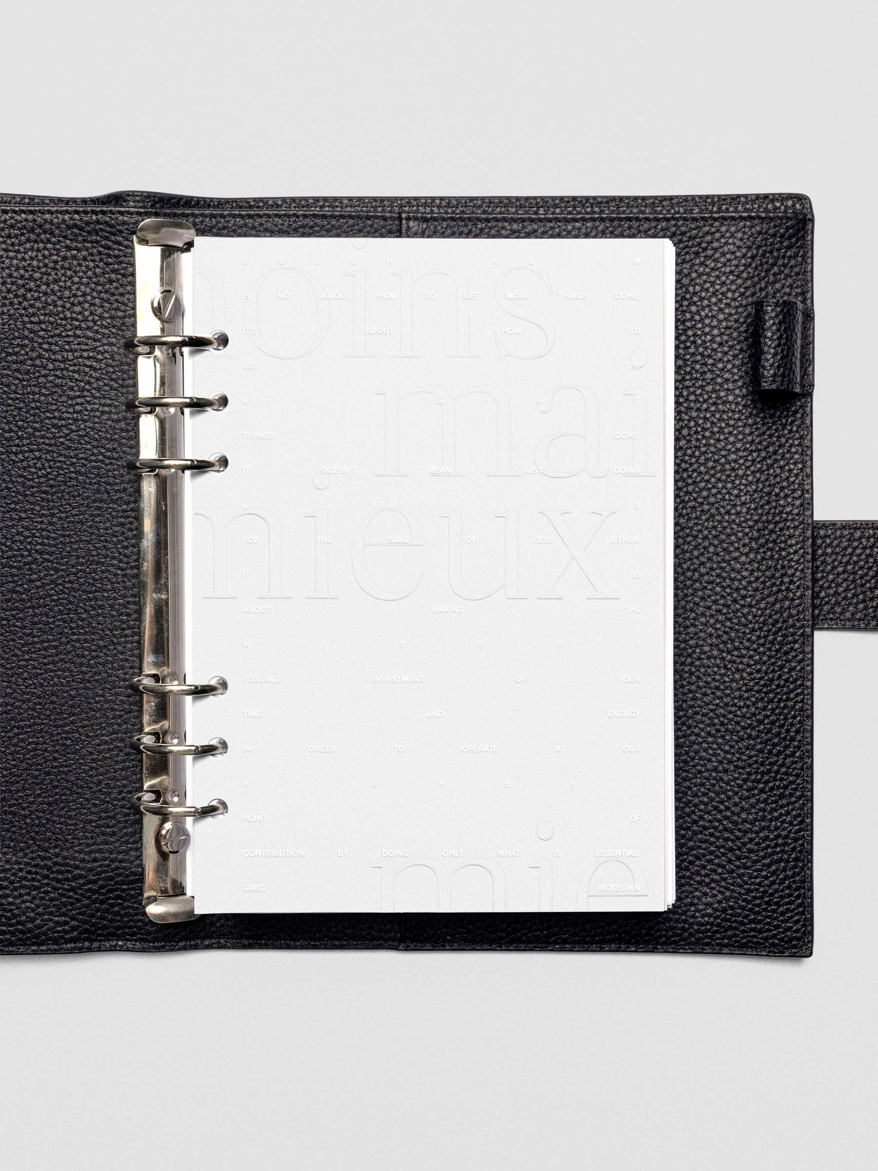 Essentialism Dashboard Duo reading "moins mai mieux" in size A5 shown in leather agenda.