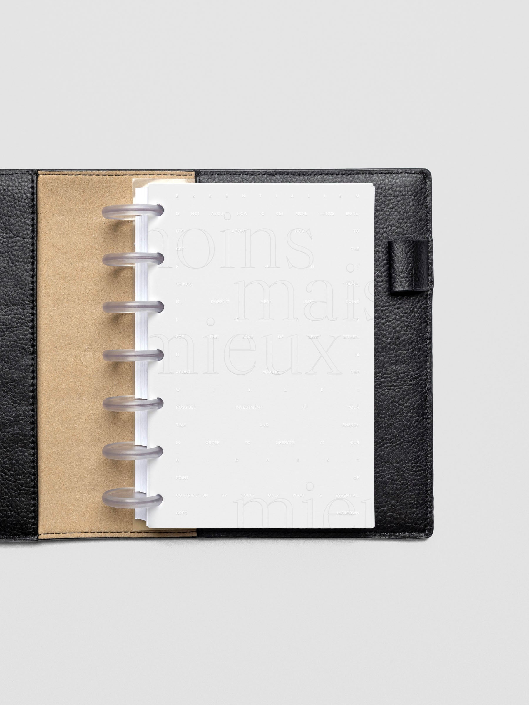 Essentialism Dashboard Duo reading "moins mai mieux" in size HP Mini; shown discbound in a leather folio.