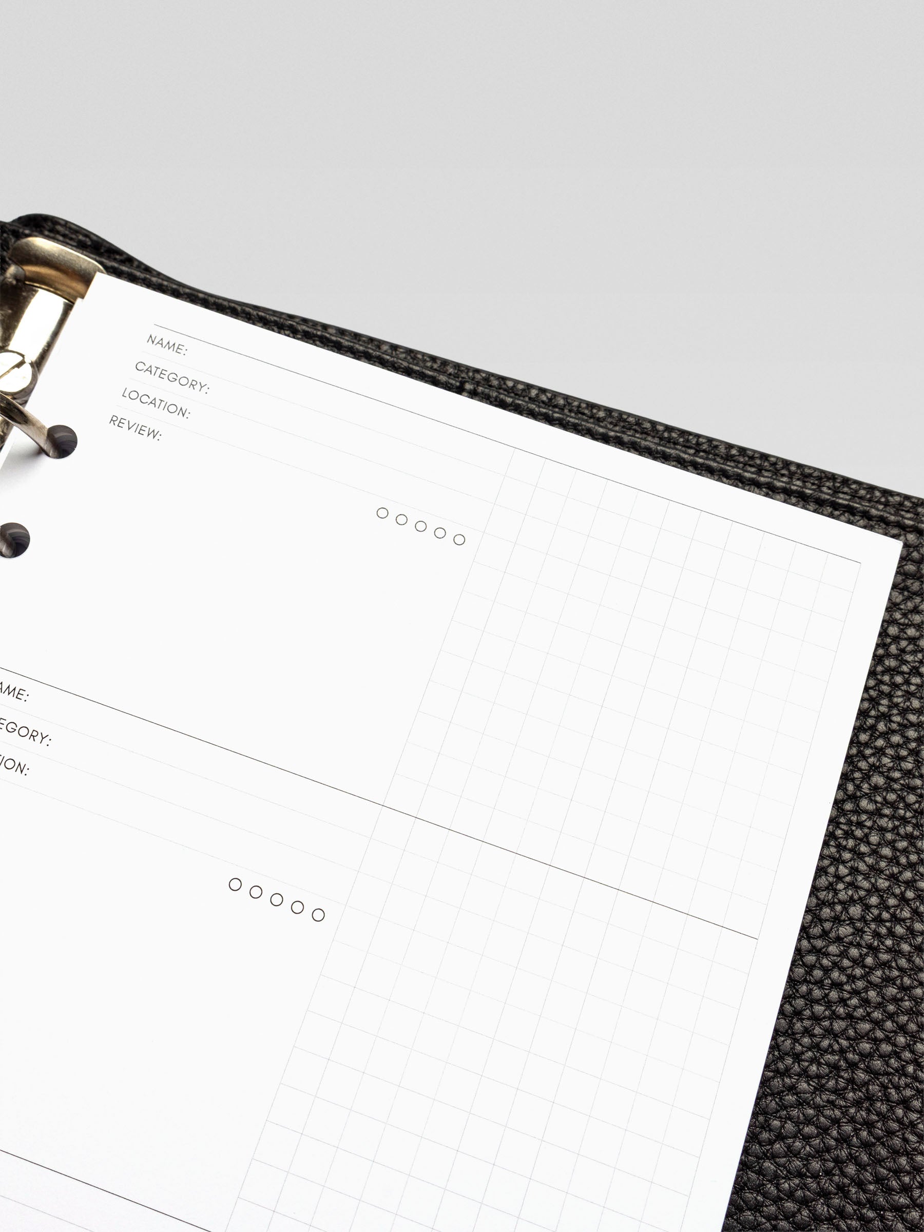 Angled view highlighting the top two entry blocks of the Experience Tracker Insert, showcasing the minimalist black ink design and grid layout.