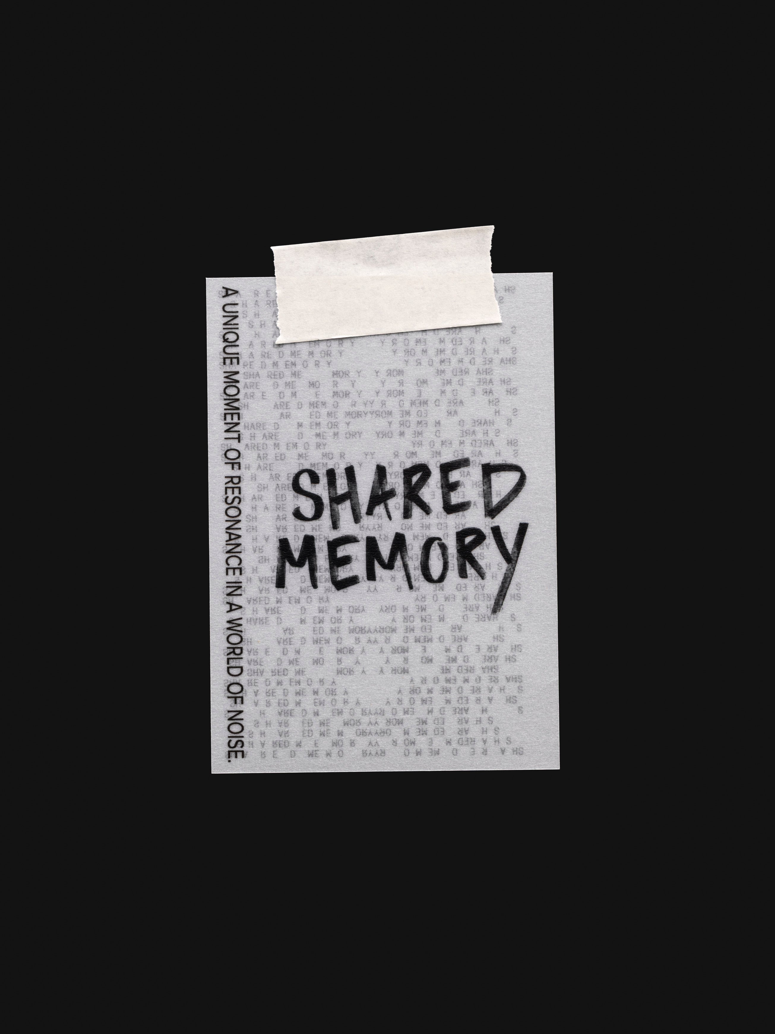 Translucent vellum journaling card with a black printed text design reading "Shared Memory" shown with tape on the top.