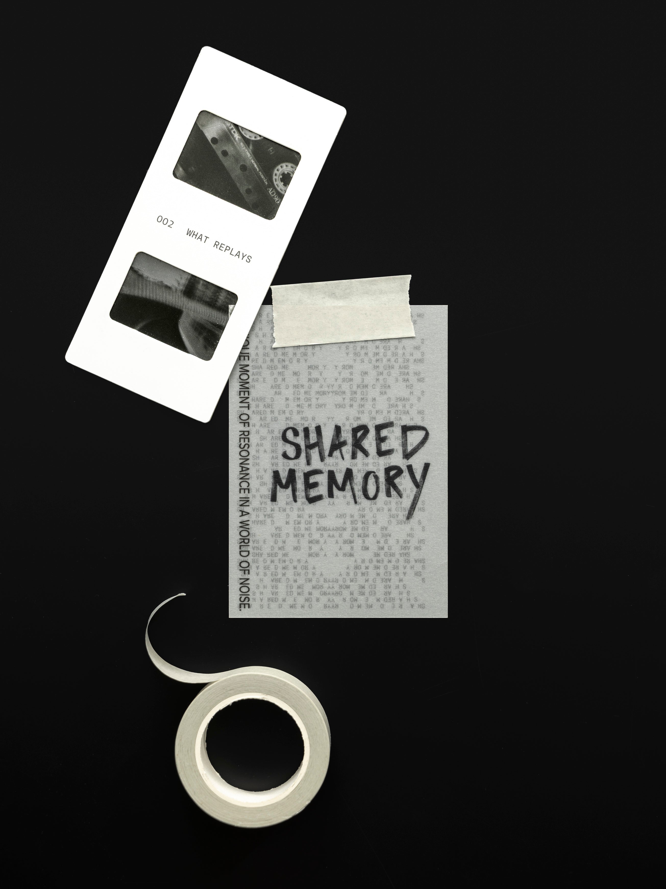 Roll of a neutral, light colored washi tape and a journaling card with tape affixed to it against a black background.