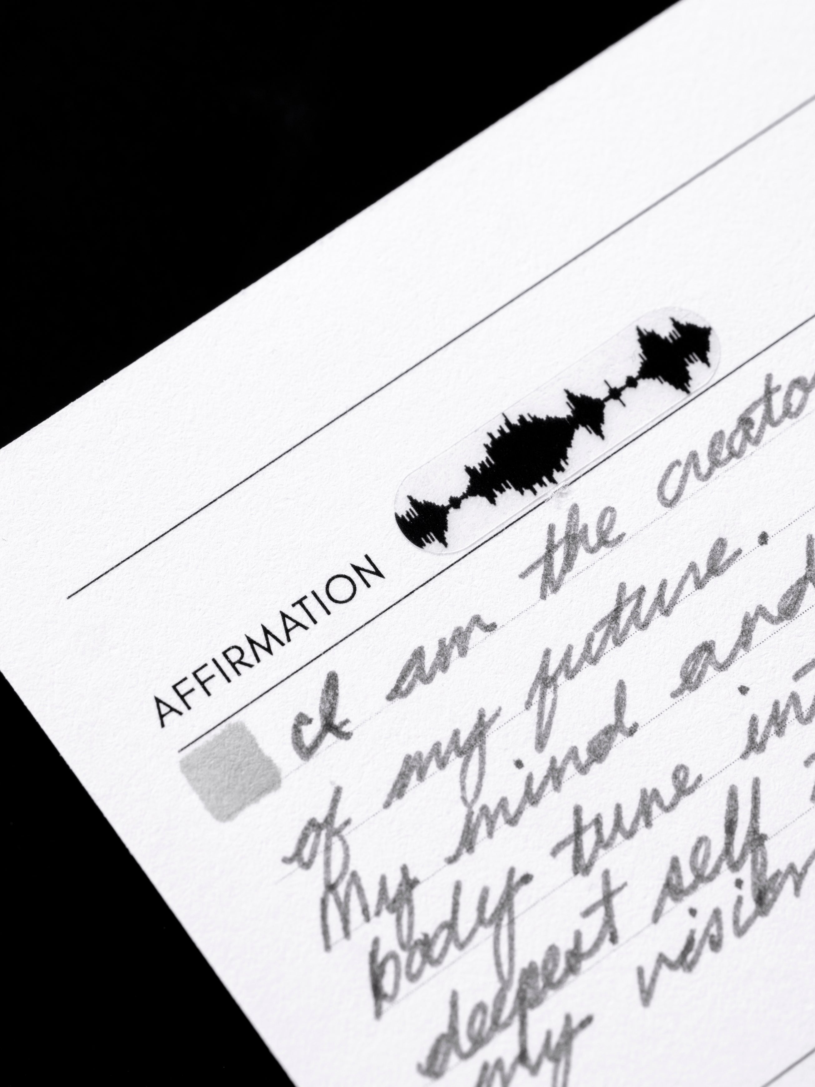 Close up view of a bar sticker, waveform design, in black in use on a planner insert.