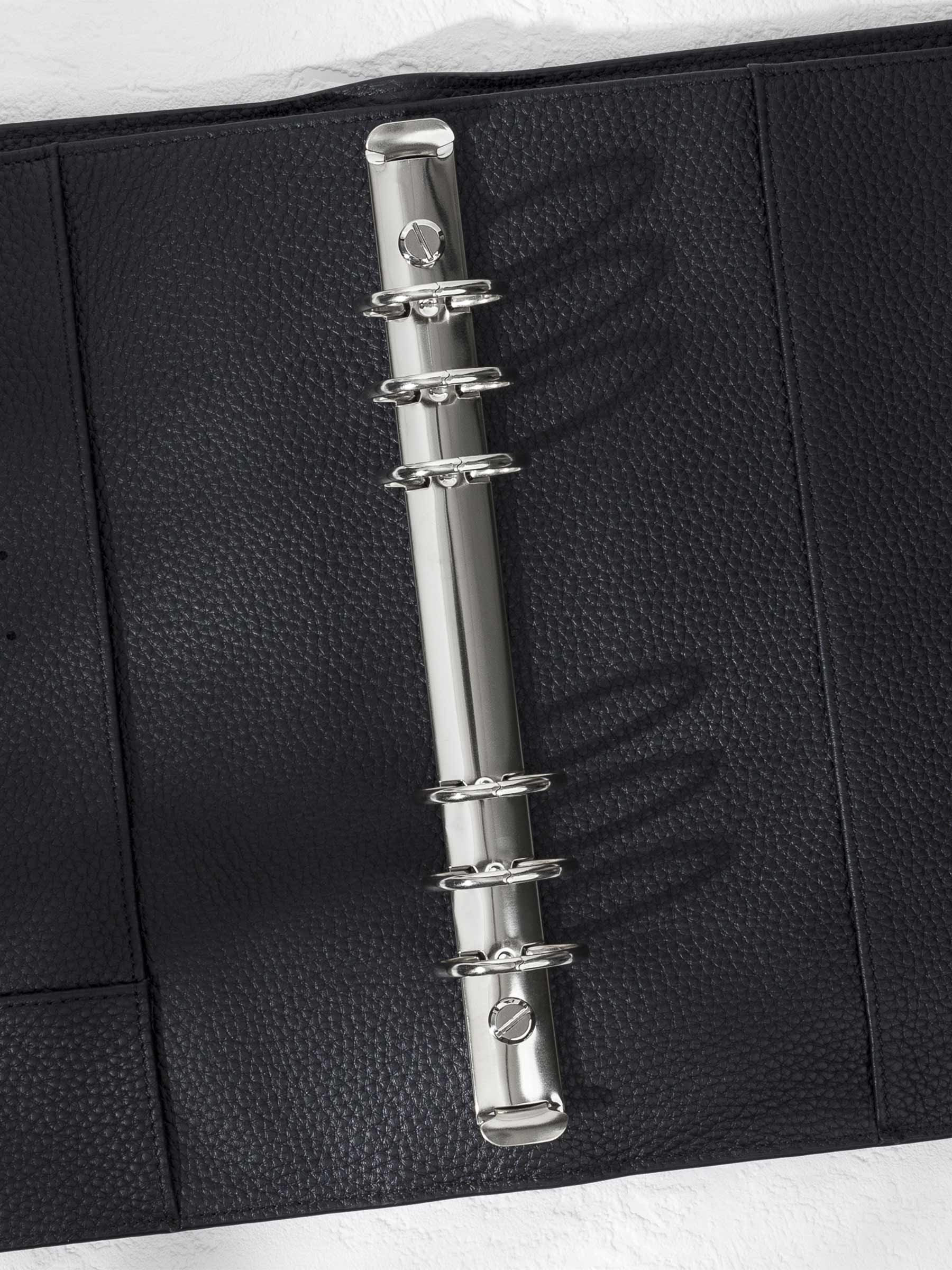 Closeup of silver hardware in a black leather agenda.