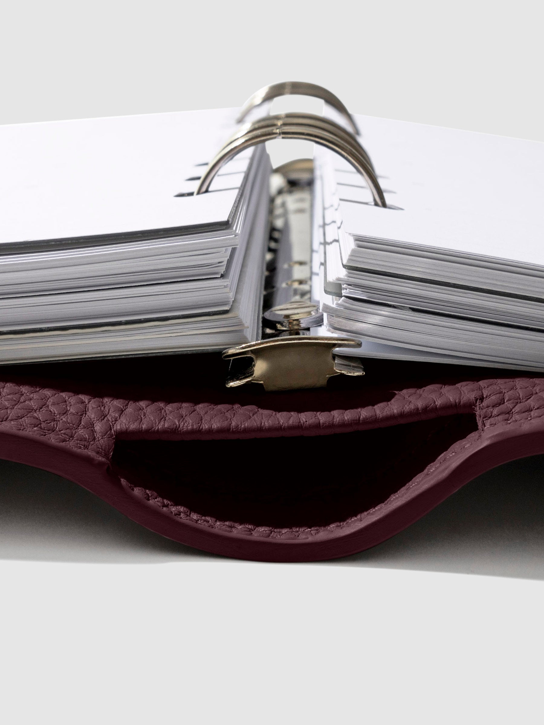Close-up of the dark burgundy leather agenda ring mechanism.