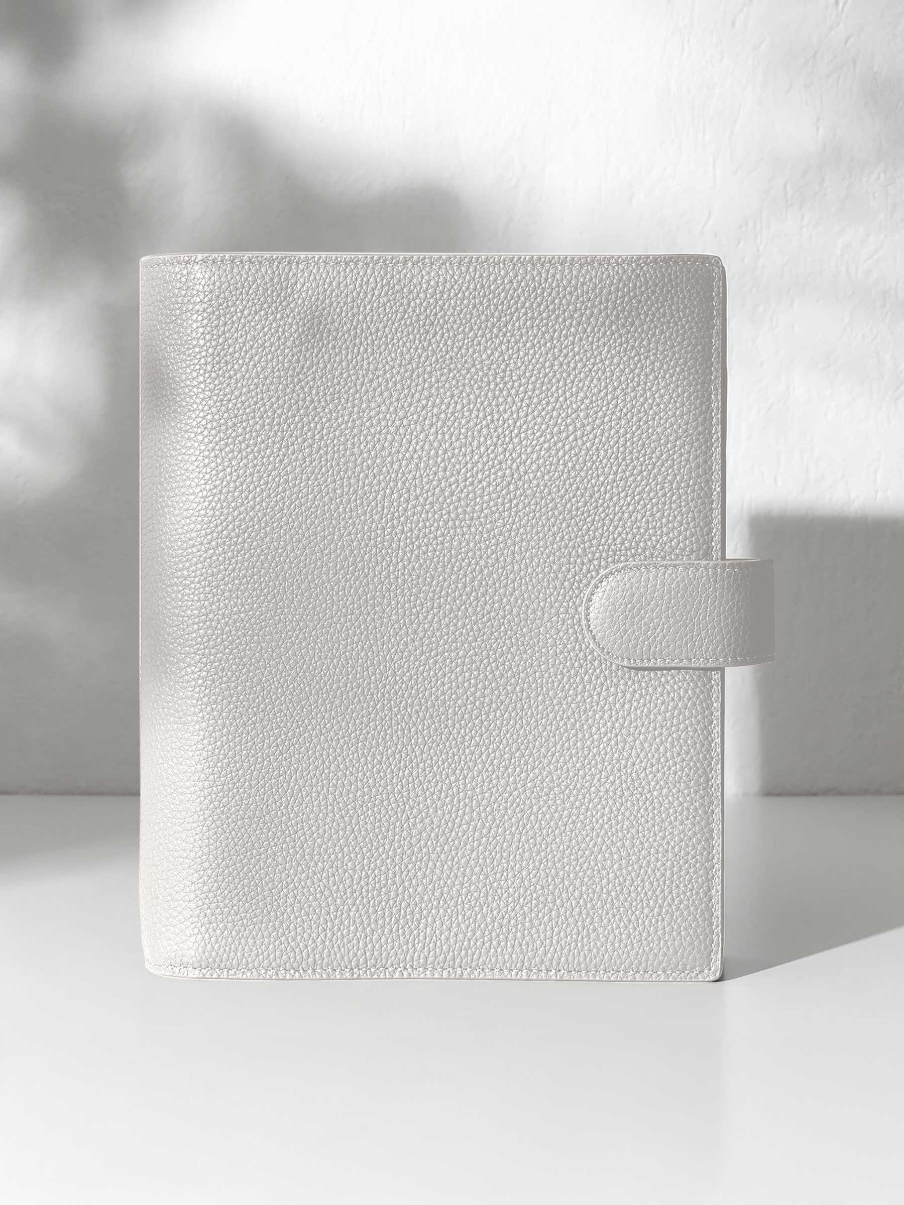 Ash leather agenda displayed displayed against a shadowed background.