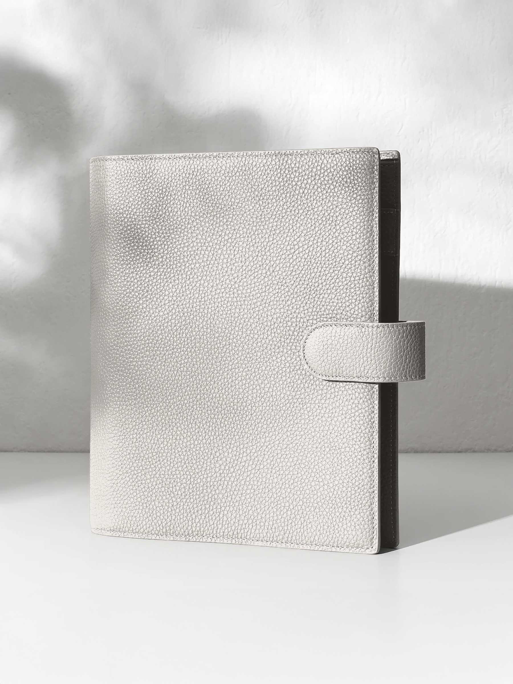Ash leather agenda displayed against a shadowed background.