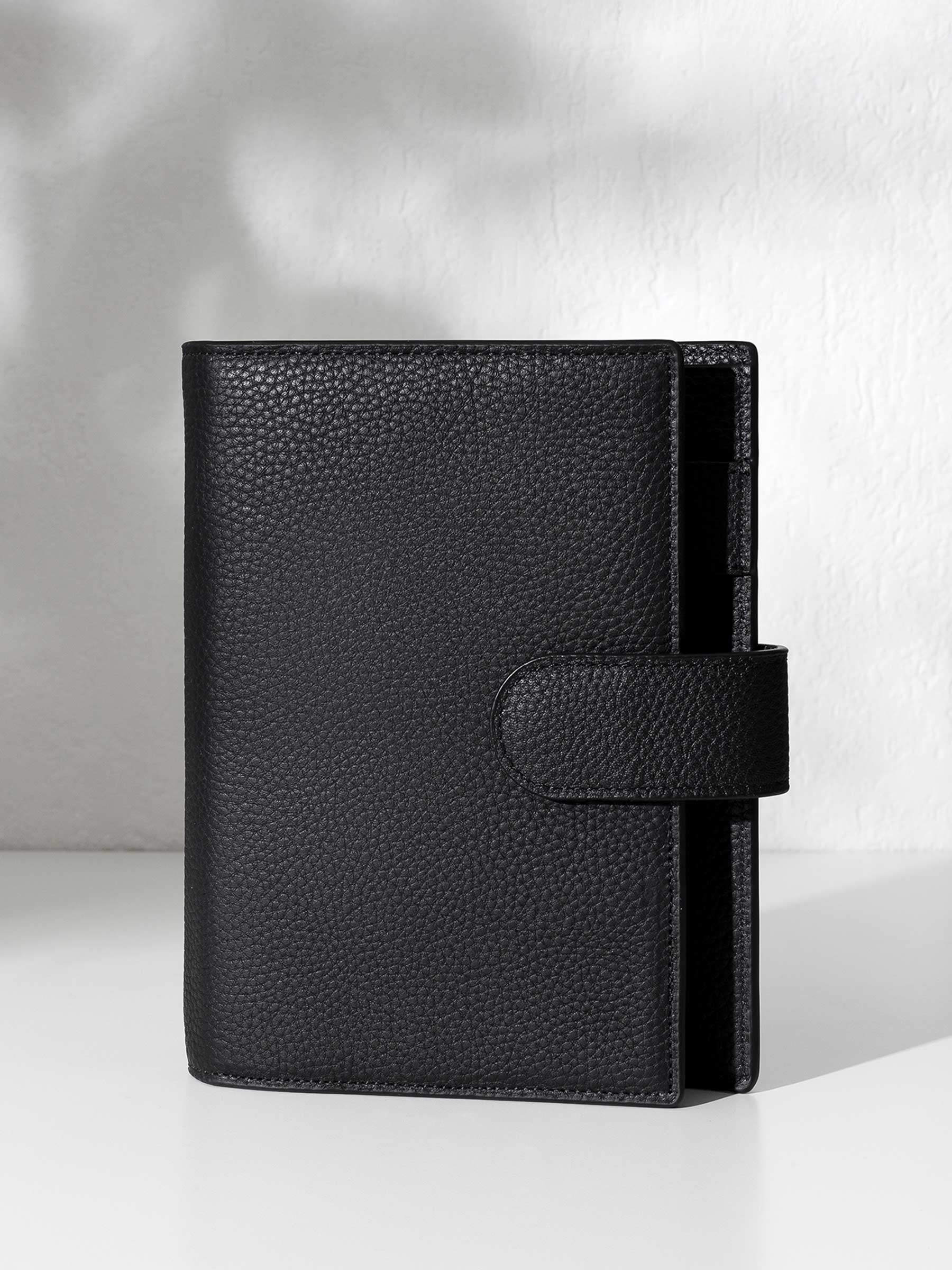 Black leather agenda displayed against a shadowed background.