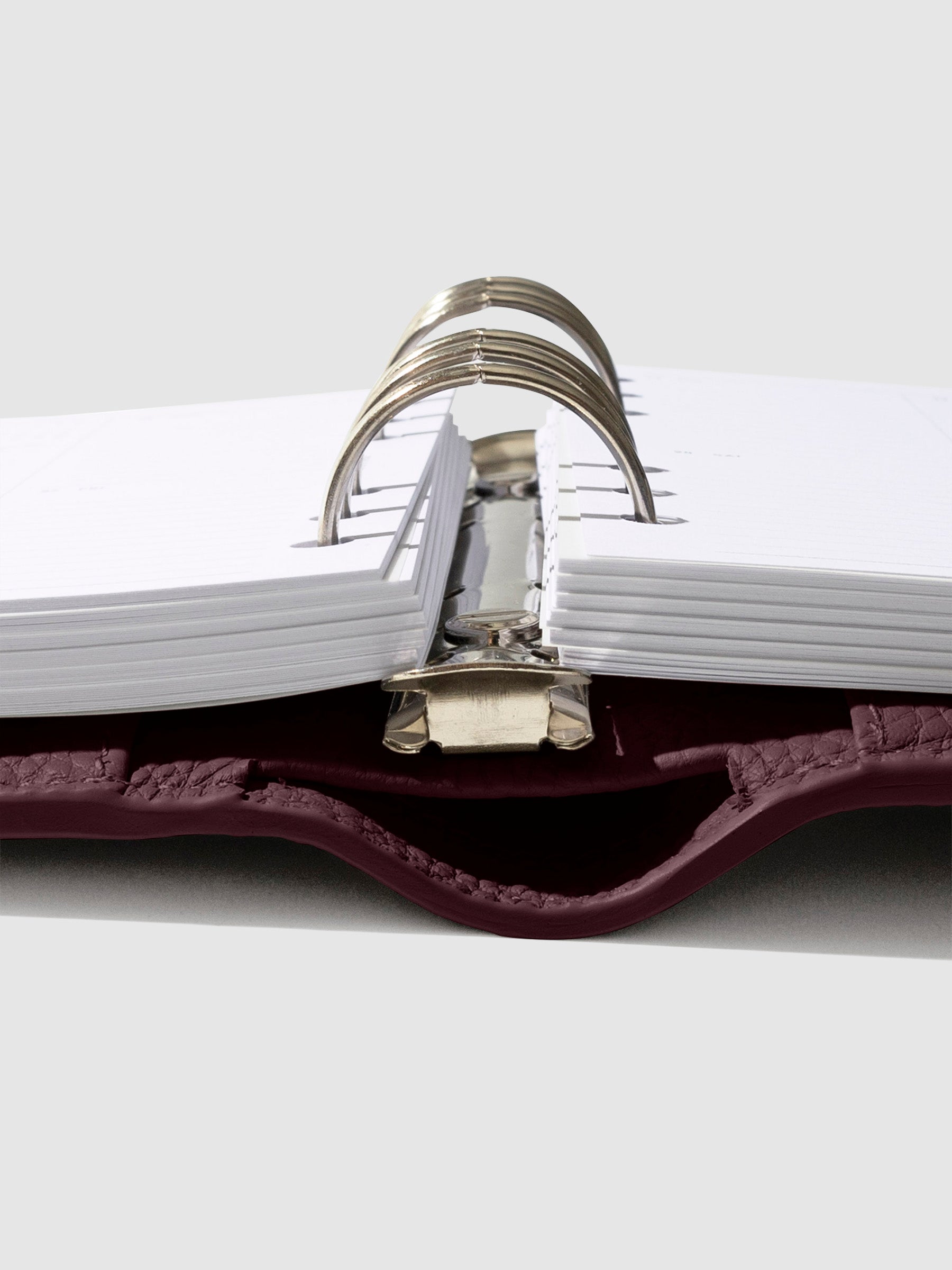 Close-up of the dark burgundy leather agenda ring mechanism.