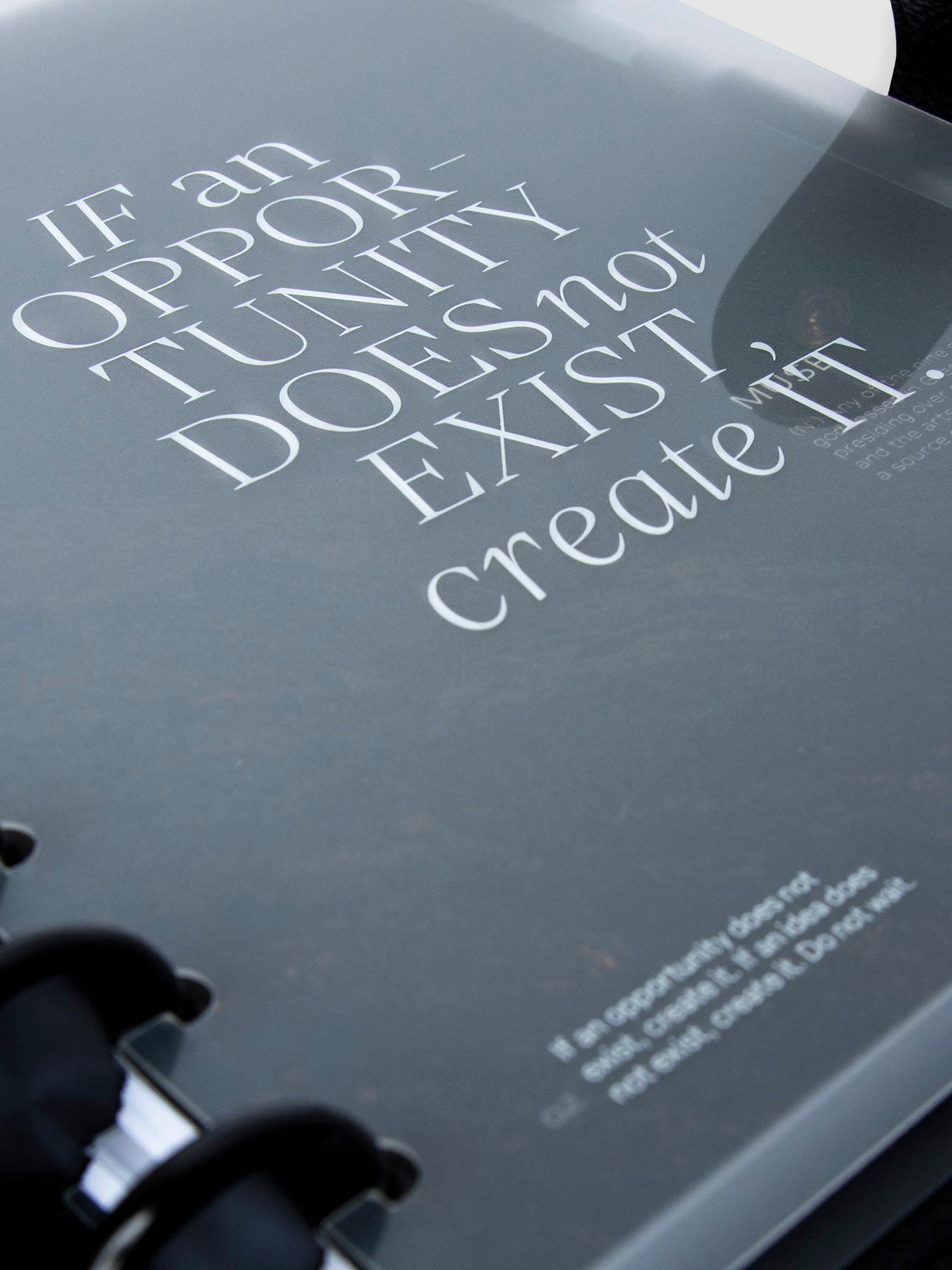 Close up on the bottom left corner of the front cover. There is text at the bottom left corner that reads "If an opportunity does not exist, create it. If an idea does not exist, create it. Do not wait." 