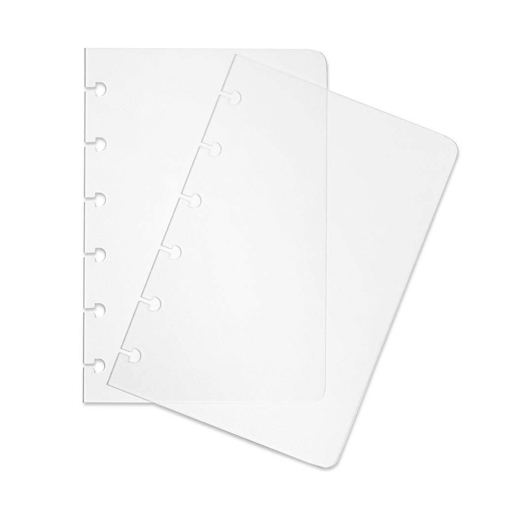 Two transparent CP Petite notebook covers laid on top of one another with the top cover tilted slightly to the right.