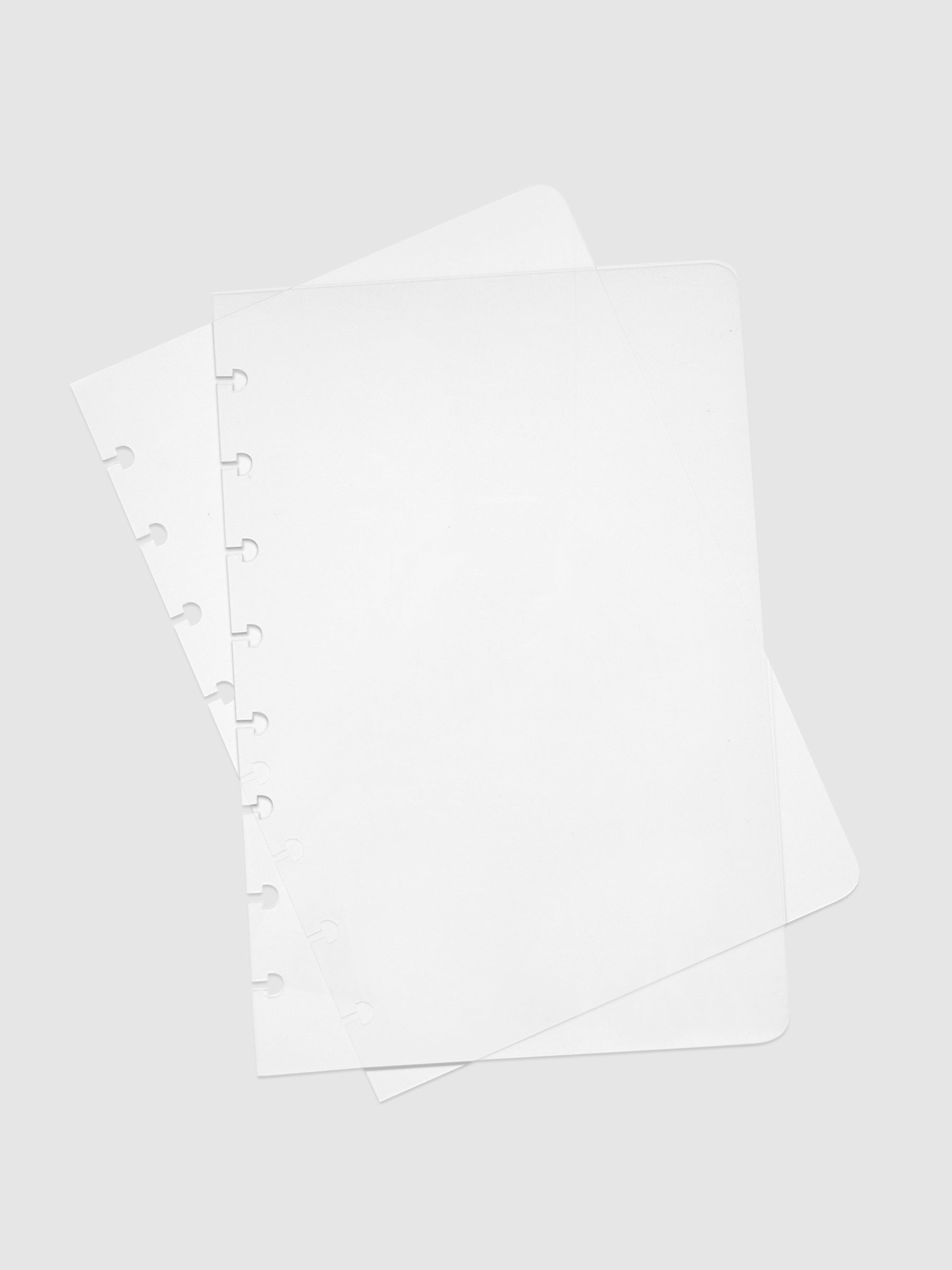 Glass Plastic Discbound Notebook Cover, Half Letter, Cloth and Paper. Two transparent notebook covers laid on top of one another with the bottom cover tilted slightly to the right.