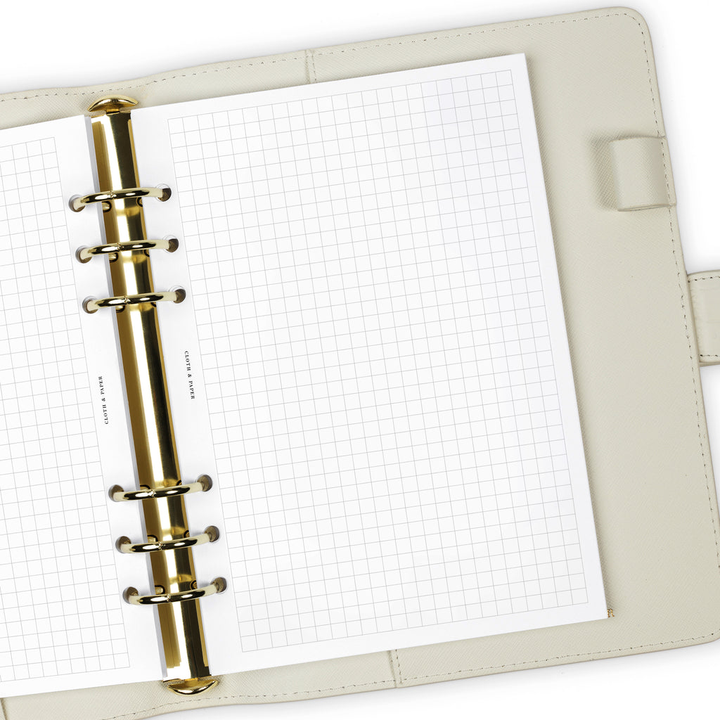 Close up of Graph Note planner inserts in use inside a white leather agenda.