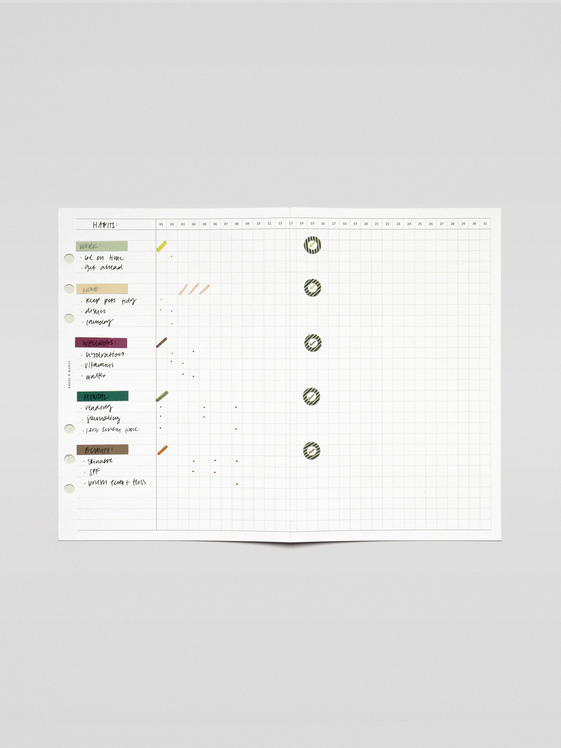 Wide view of the fold-out insert fully extended displaying a monthly habit grid with labeled tasks on the left and completed days marked with stickers.