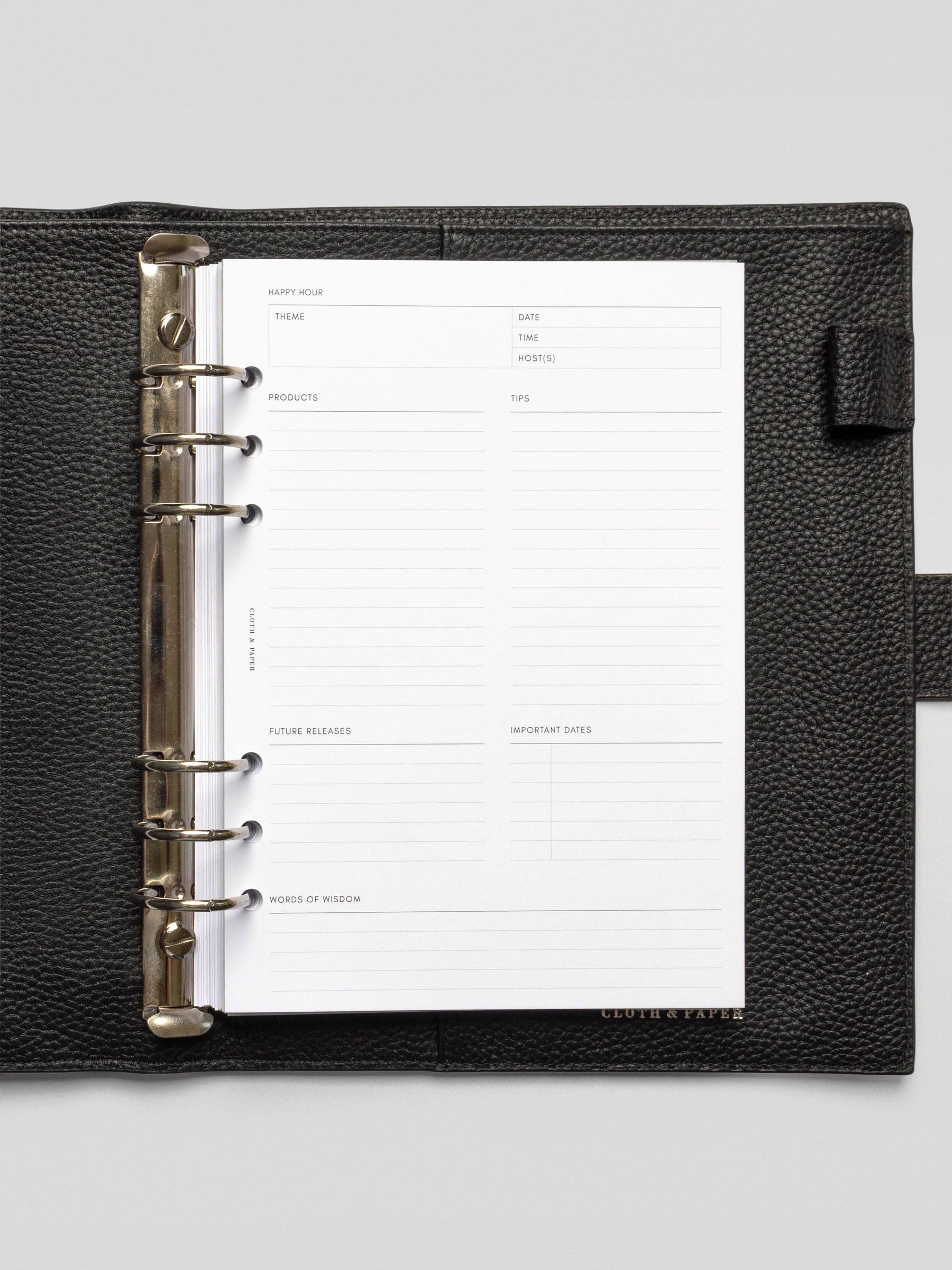 Open black leather planner featuring a blank Happy Hour Notes Insert with structured sections for theme, products, tips, and more.