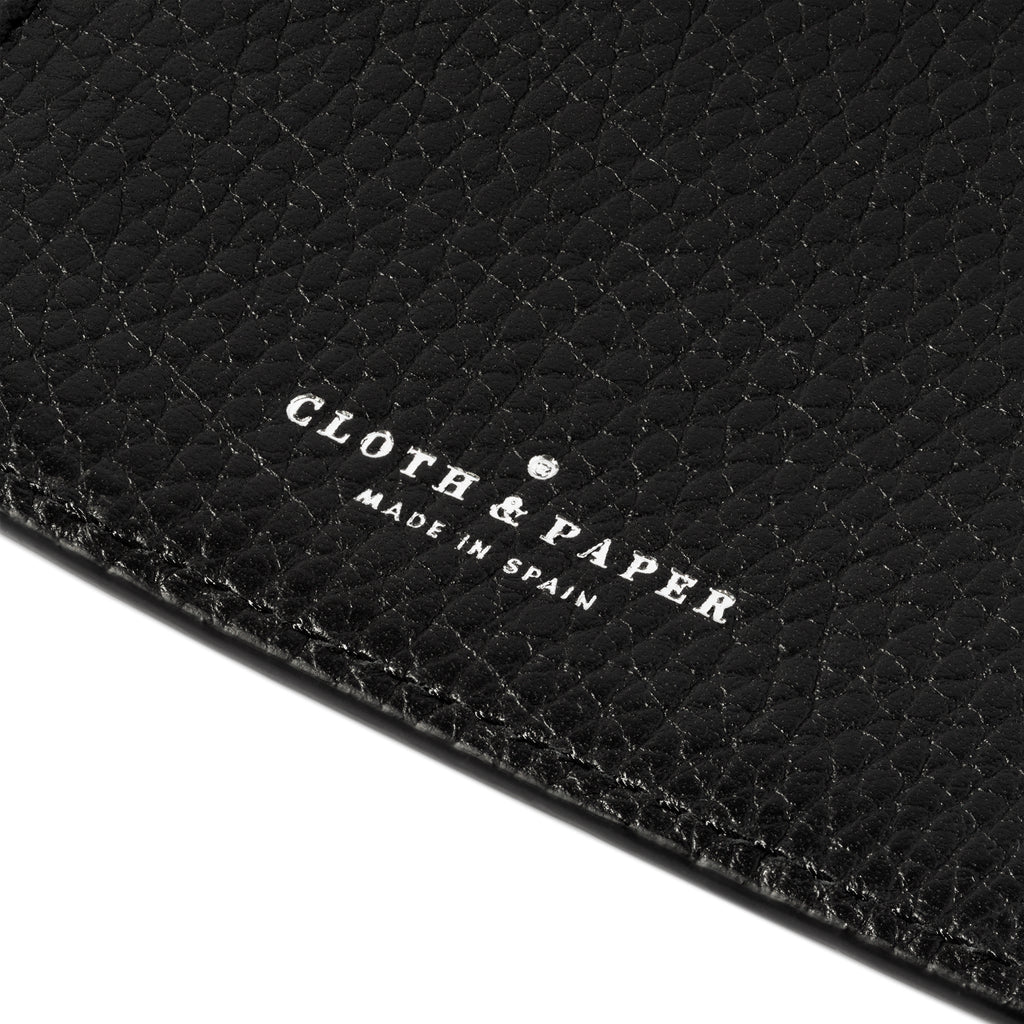 Closeup of silver embossed Cloth and Paper logo in a black leather folio.  