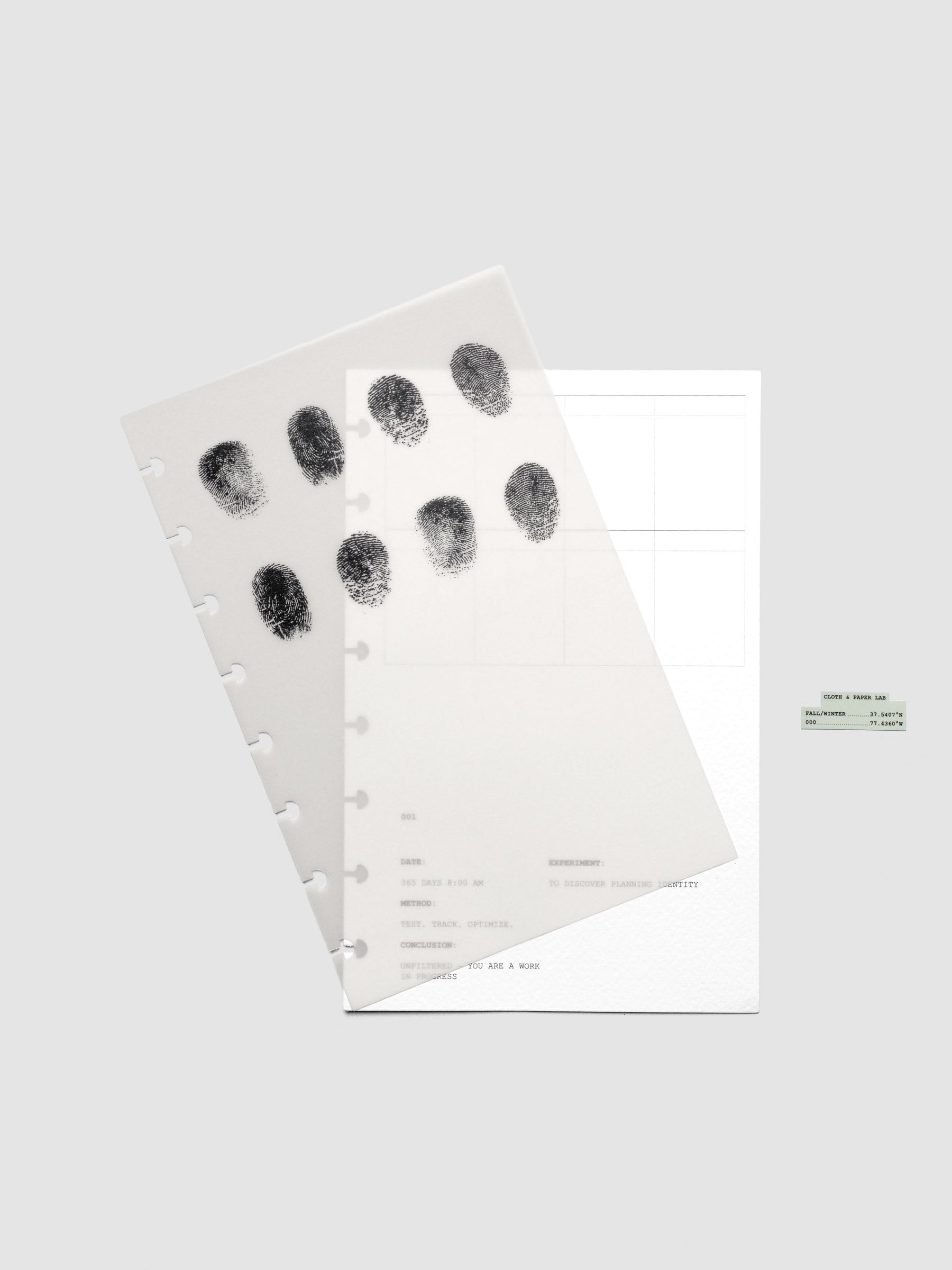 Two layered Half Letter sized planner dashboards, one semi-transparent, one matte, featuring a fingerprint design shown offset from one another.