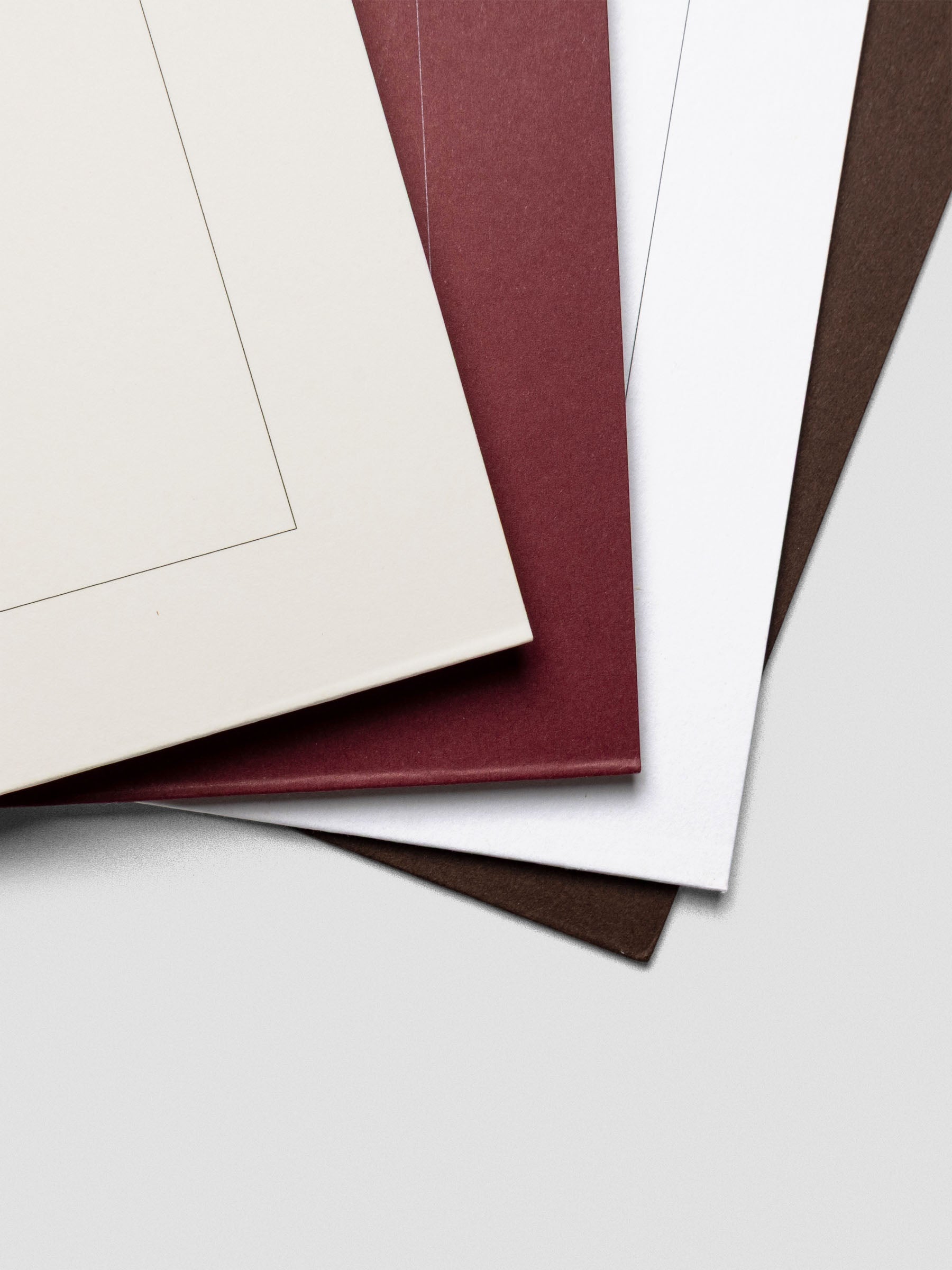 Close-up view of the folder corners in Cream, Bordeaux, White, and Espresso, highlighting the thick cardstock texture and distinct color contrast.