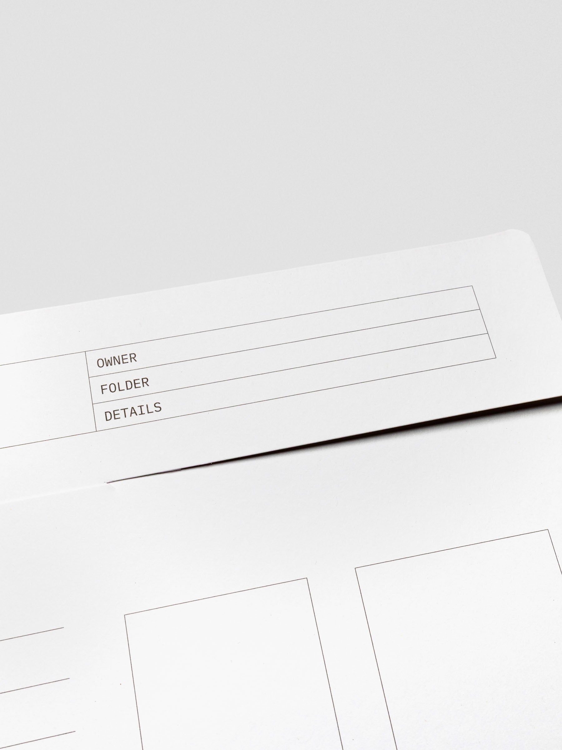 Close-up of the tabbed flap closure and labeling fields on the white Index Folder, highlighting the structured lines and minimal design.