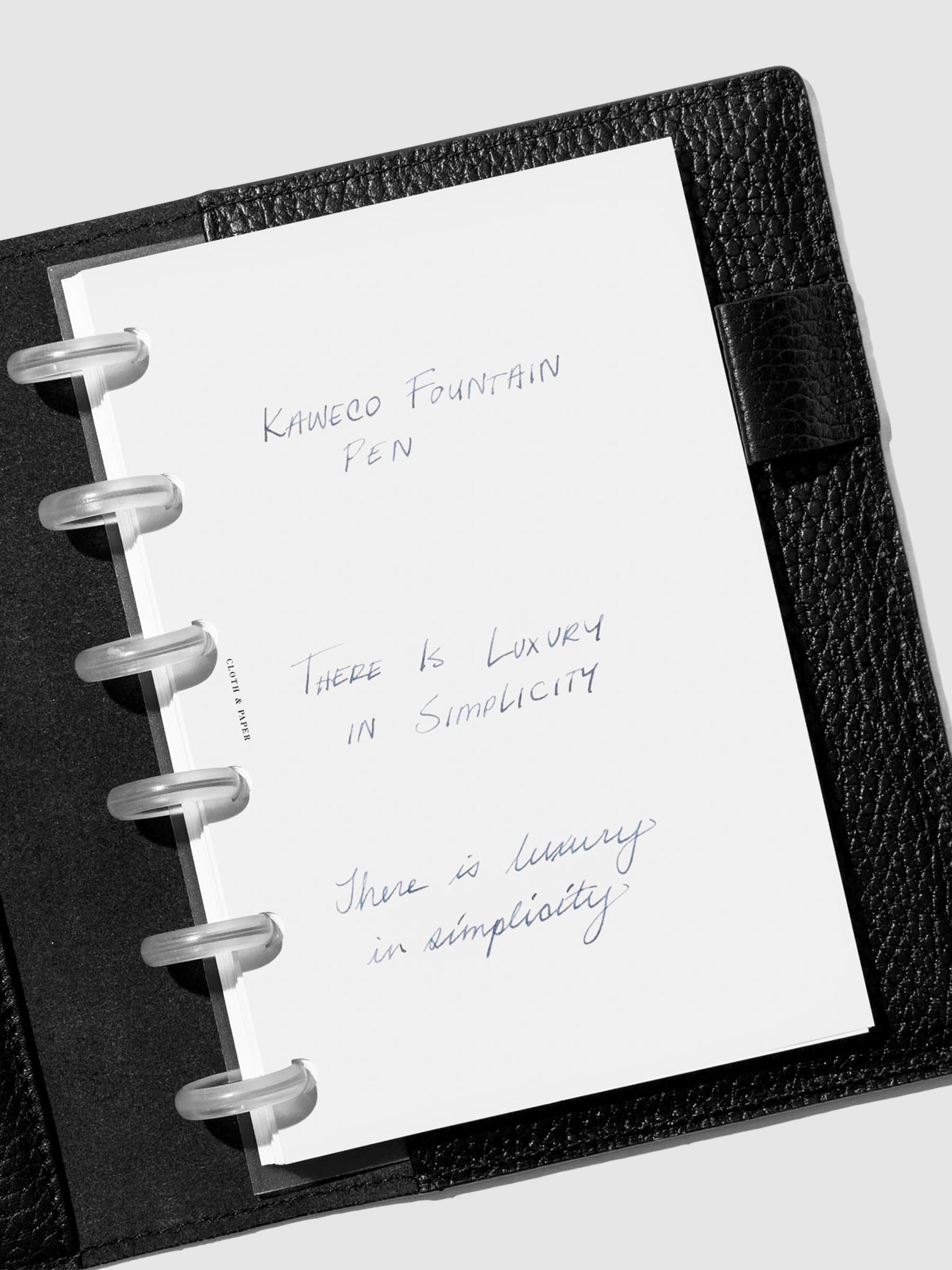 Writing sample shown in a black leather folio. 