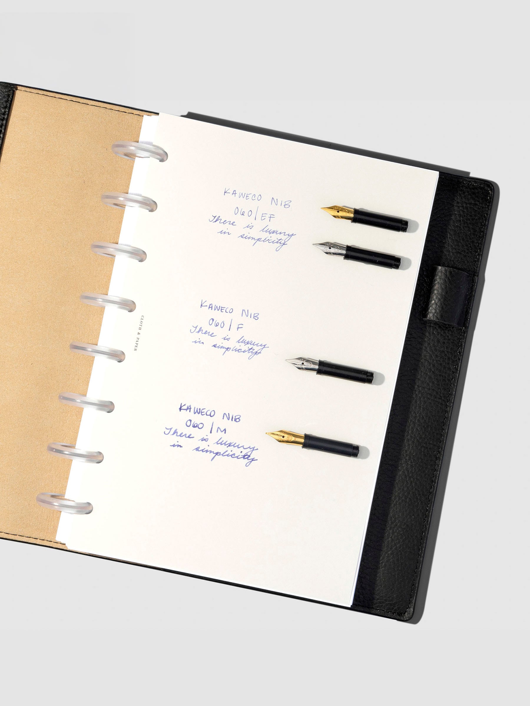 Writing sample displayed inside a black leather planner.