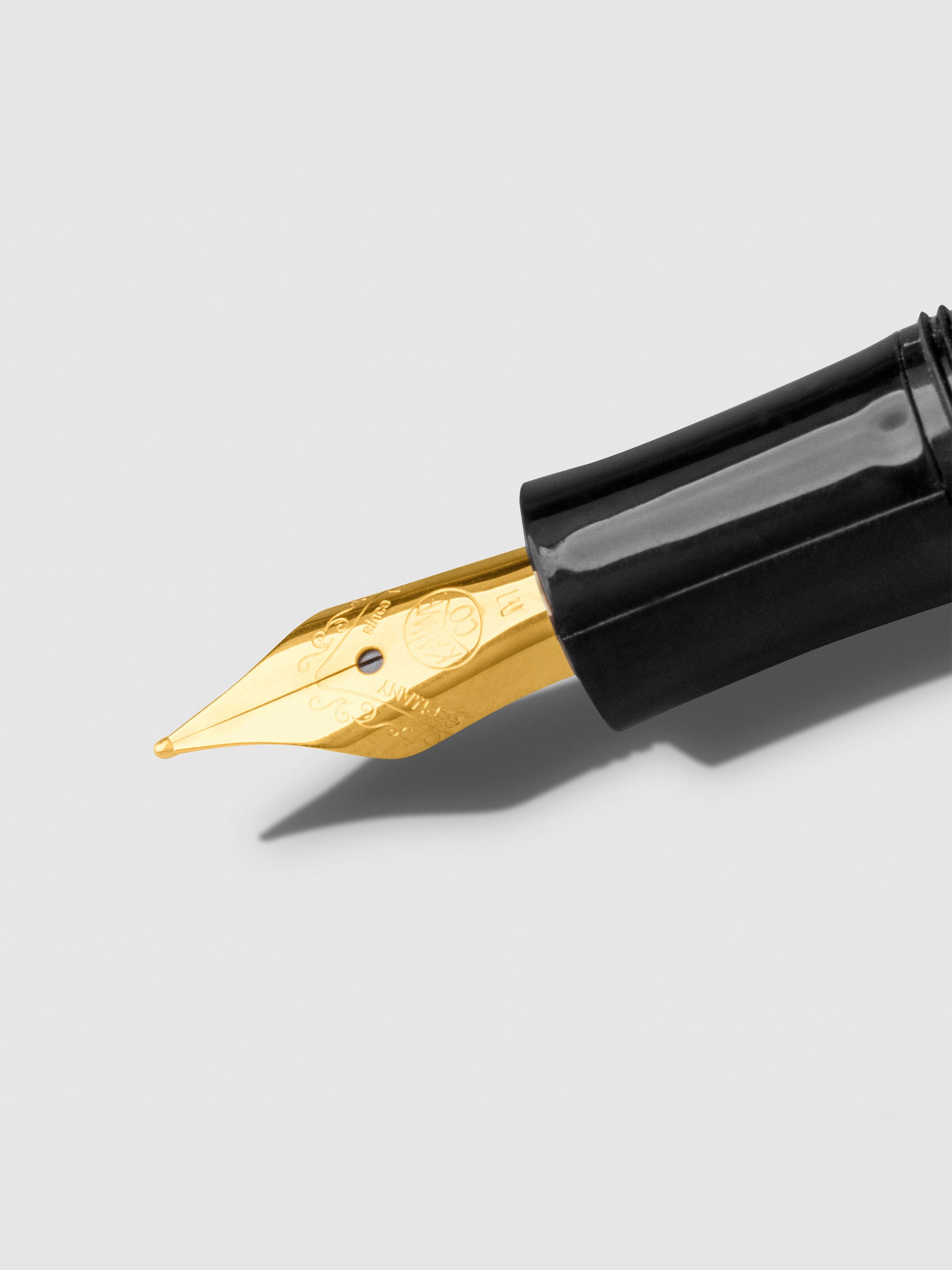 Closeup of gold nib on a neutral background.