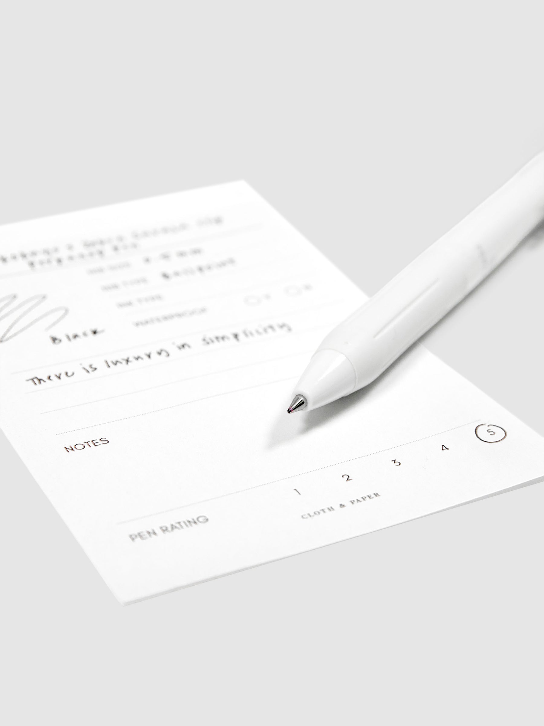 Kokuyo x Zebra Sarasa Clip Perpanep Pen, Cloth and Paper. Close up on pen nib resting on pen test sheet.